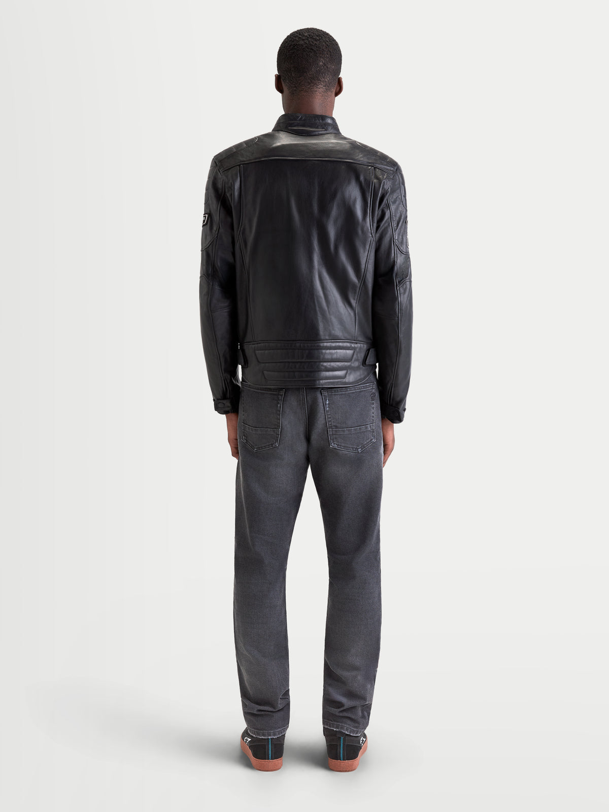 Alpinestars Revern Leather Jacket, men's urban contemporary motorcycle leather jacket in black, rear view on a model wearing jeans and casual riding shoes, showcasing the distressed full-grain bovine leather construction and heritage biker styling