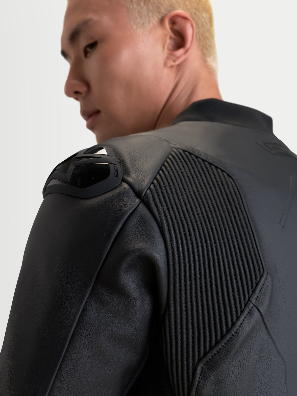Alpinestars Caliber V2 Leather Jacket, Black, close-up view focusing on the shoulder armor and accordion mobility panels on a rider