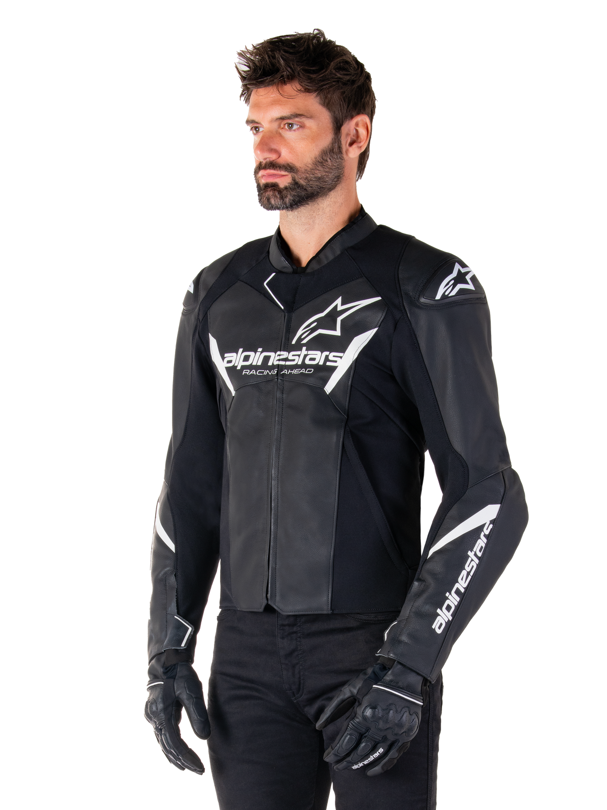 Alpinestars Faster V3 Lederjacke, Sport-Motorradjacke, Schwarz und Weiß, auffälliges weißes Alpinestars-Logo und 'Racing Ahead'-Schriftzug auf der Brust, Stern-Logos auf den Schultern, hochwertige Lederkonstruktion mit Stretcheinsätzen, getragen von einem Modell mit schwarzer Hose und Handschuhen