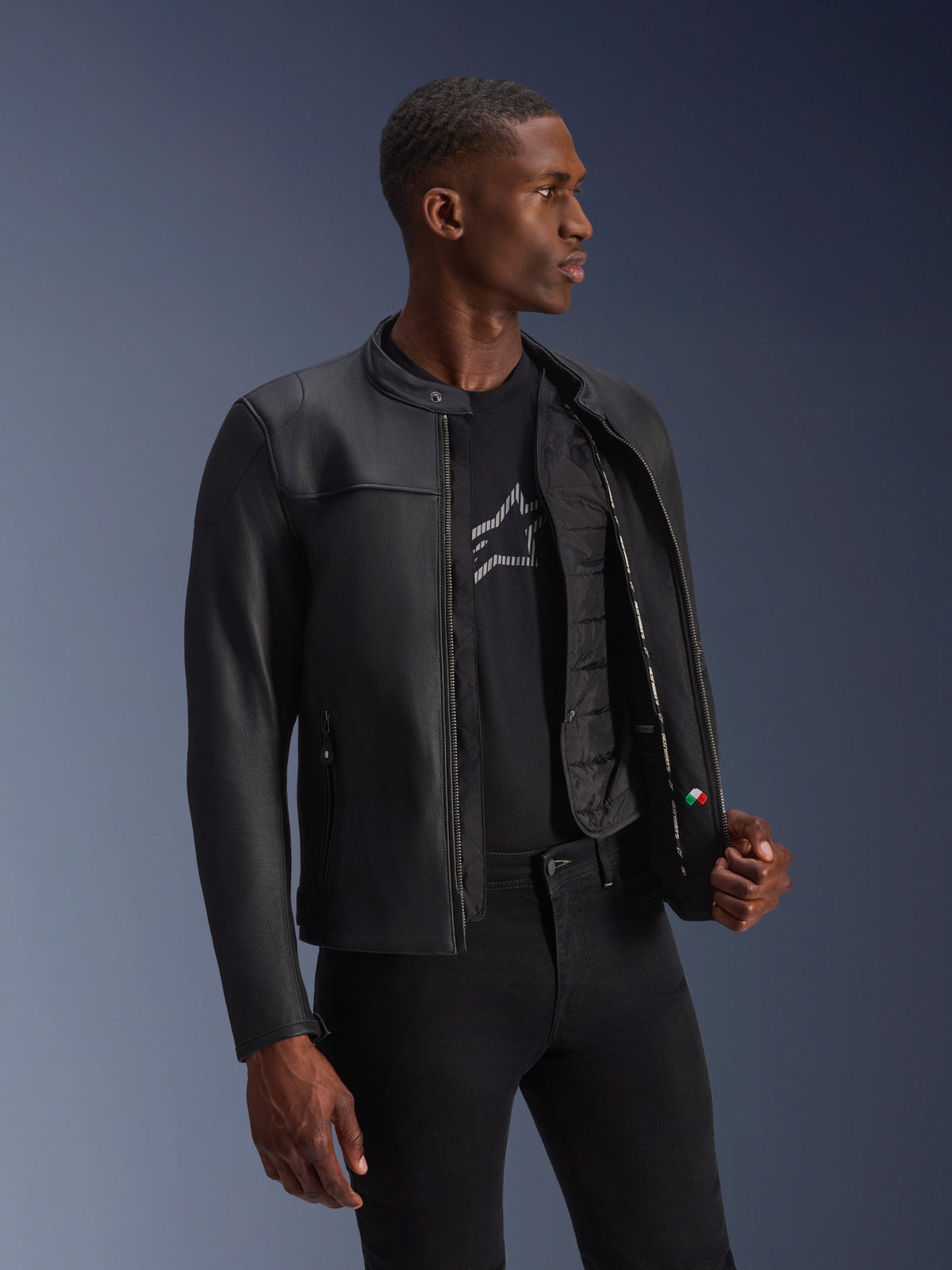 Alpinestars Blacktrack Lederjacke, schwarzes Rindsleder, offen getragen an einem Model mit sichtbarer Thermoweste.