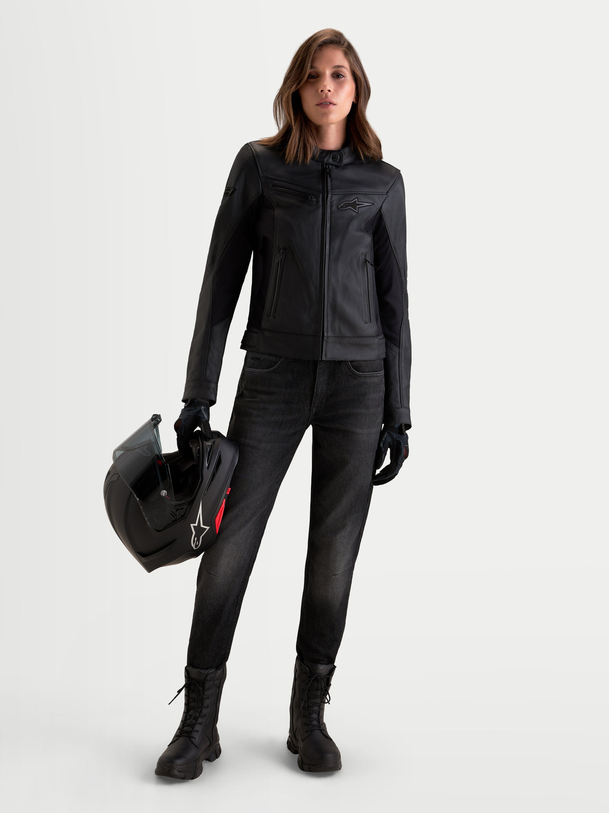 Alpinestars Stella Maver X Lederjacke, Damen-Motorradjacke in Schwarz, Vorderansicht eines Models mit Lederjacke und Helm, aus weichem Rindsleder im urbanen, modernen Design