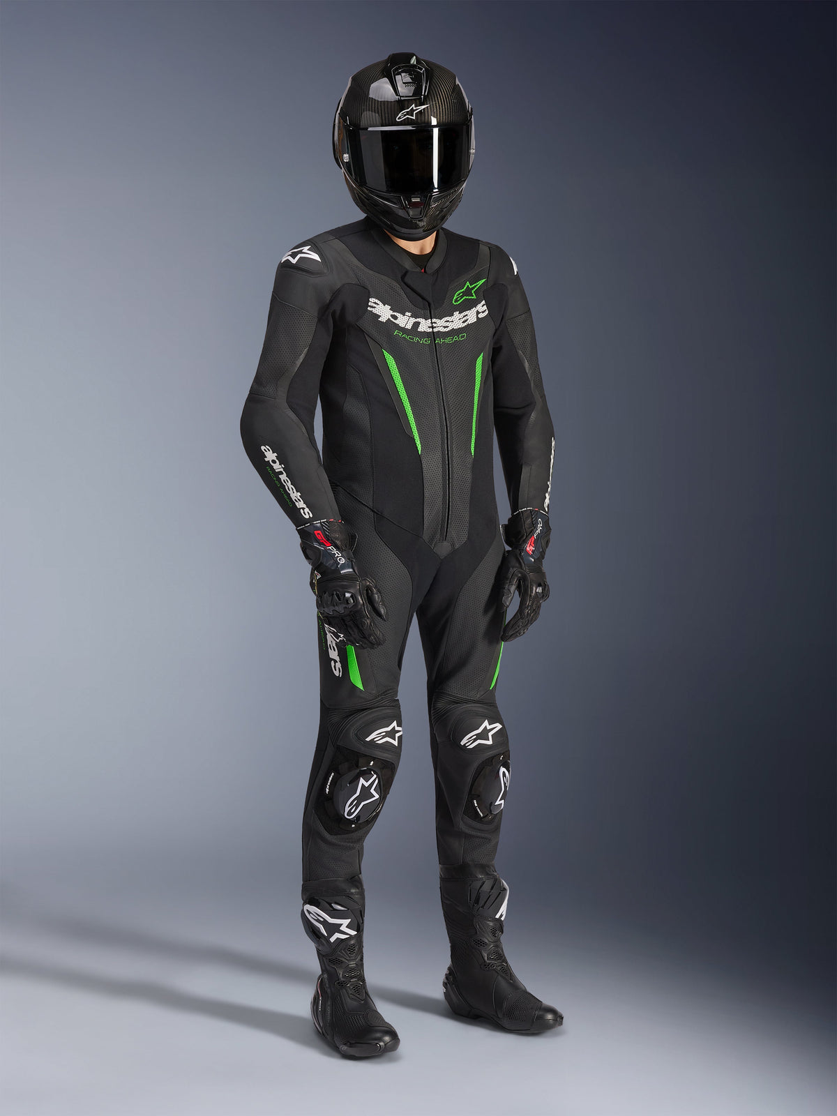 Alpinestars GP Force V2 Leather Suit - 1Piece, Black and Green, worn with matching black helmet, racing gloves, and boots, featuring bright green accents and bold white Alpinestars branding, professional track and sport riding gear