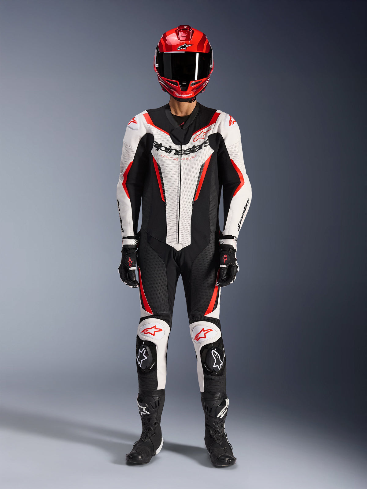 Alpinestars GP Force V2 Lederkombi – 1-teilig, Weiß, Schwarz und Rot Fluo, komplette Rennausrüstung inklusive rotem Helm, schwarzen Handschuhen und Stiefeln, mit aerodynamischem Design und Alpinestars-Branding auf Brust und Knien