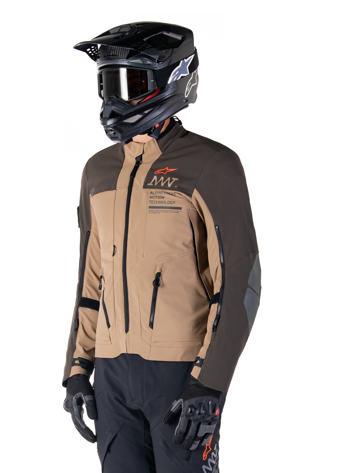 Alpinestars AMT-8 Stretch Drystar® XF Jacke, Adventure-Motorradjacke, Dunkelbraun und Dunkles Khaki, getragen mit einem schwarzen Offroad-Helm und Goggles, mit Alpinestars Motion Technology Branding und Belüftungsöffnungen mit Reißverschluss.