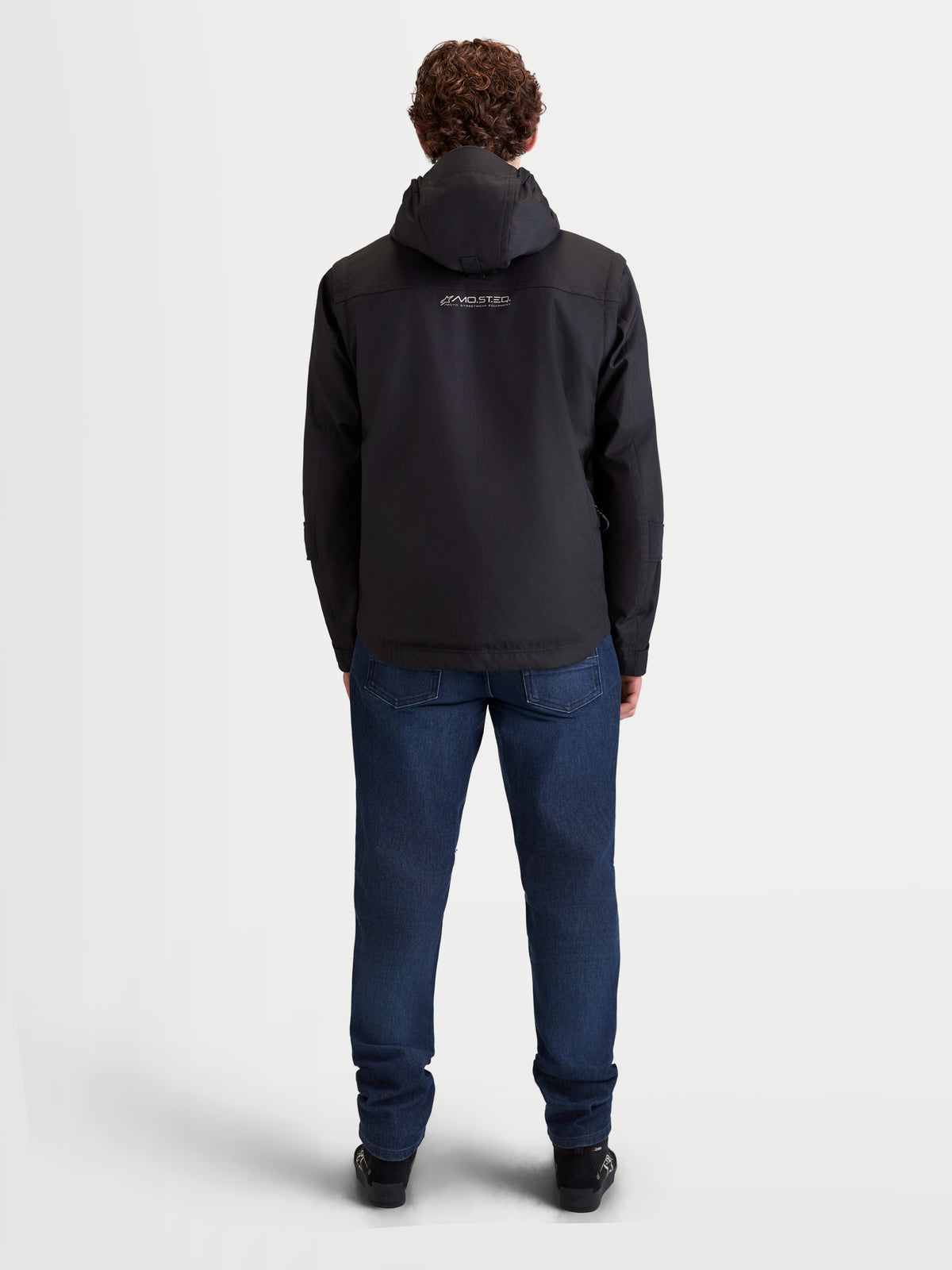 Alpinestars Morfex Parka WP Jacke, urbane Motorrad-Textiljacke für Herren in Schwarz, Rückansicht des Models mit integrierter Kapuze und Motorrad-Jeans