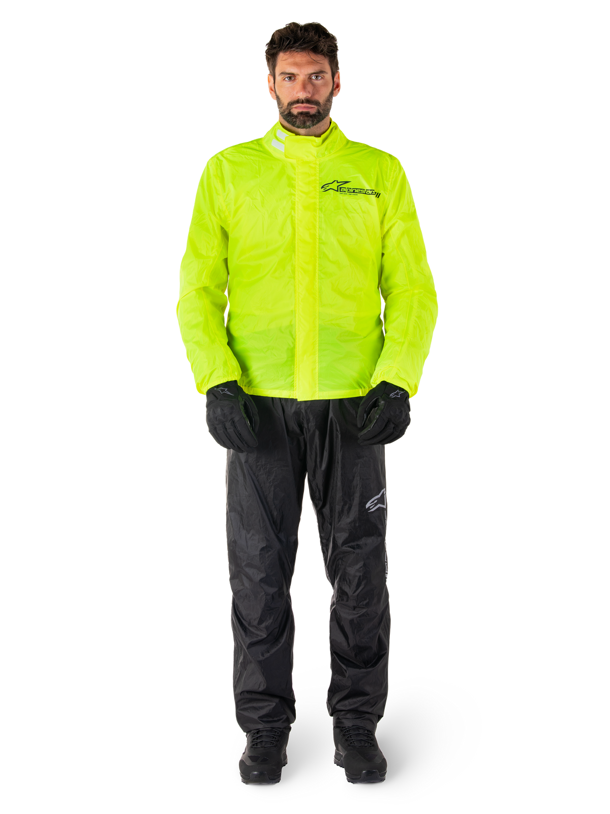Alpinestars Hurricane Rain V2 Jacke und Hose, Neongelb und Schwarz, wasserdichte Motorrad-Regenkombi, getragen mit schwarzen Handschuhen und Stiefeln, Alpinestars-Logo auf der Brust und am Bein