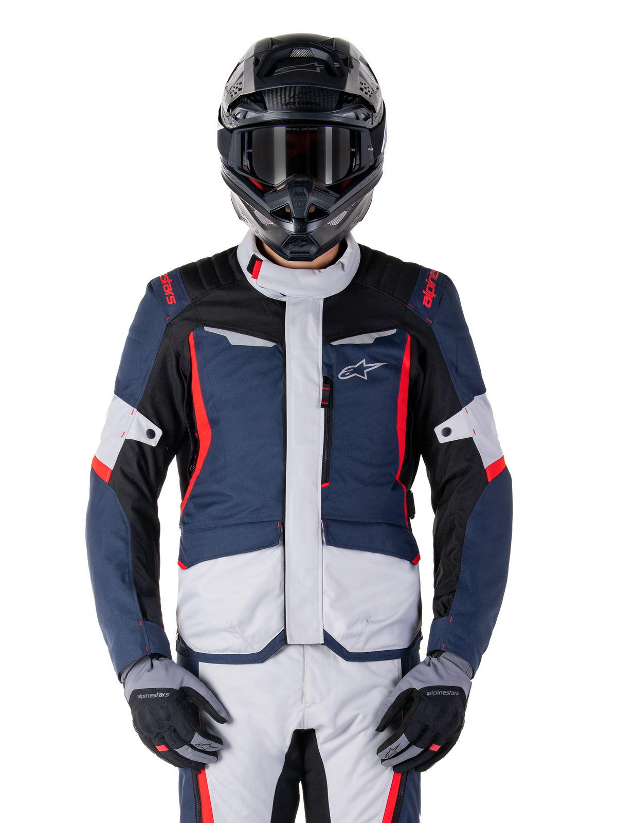 Alpinestars ST-1 wasserdichte Jacke, Adventure-Tourenjacke, Dunkelblau, Schwarz und leuchtendes Rot, getragen mit einem schwarzen Adventure-Helm und grauen Handschuhen, mit hellgrauen Einsätzen und roten Akzenten an Schultern und Reißverschlüssen, schlankes Design mit Alpinestars-Branding auf der Brust, strapazierfähige wasserdichte Ausrüstung zum Motorradfahren