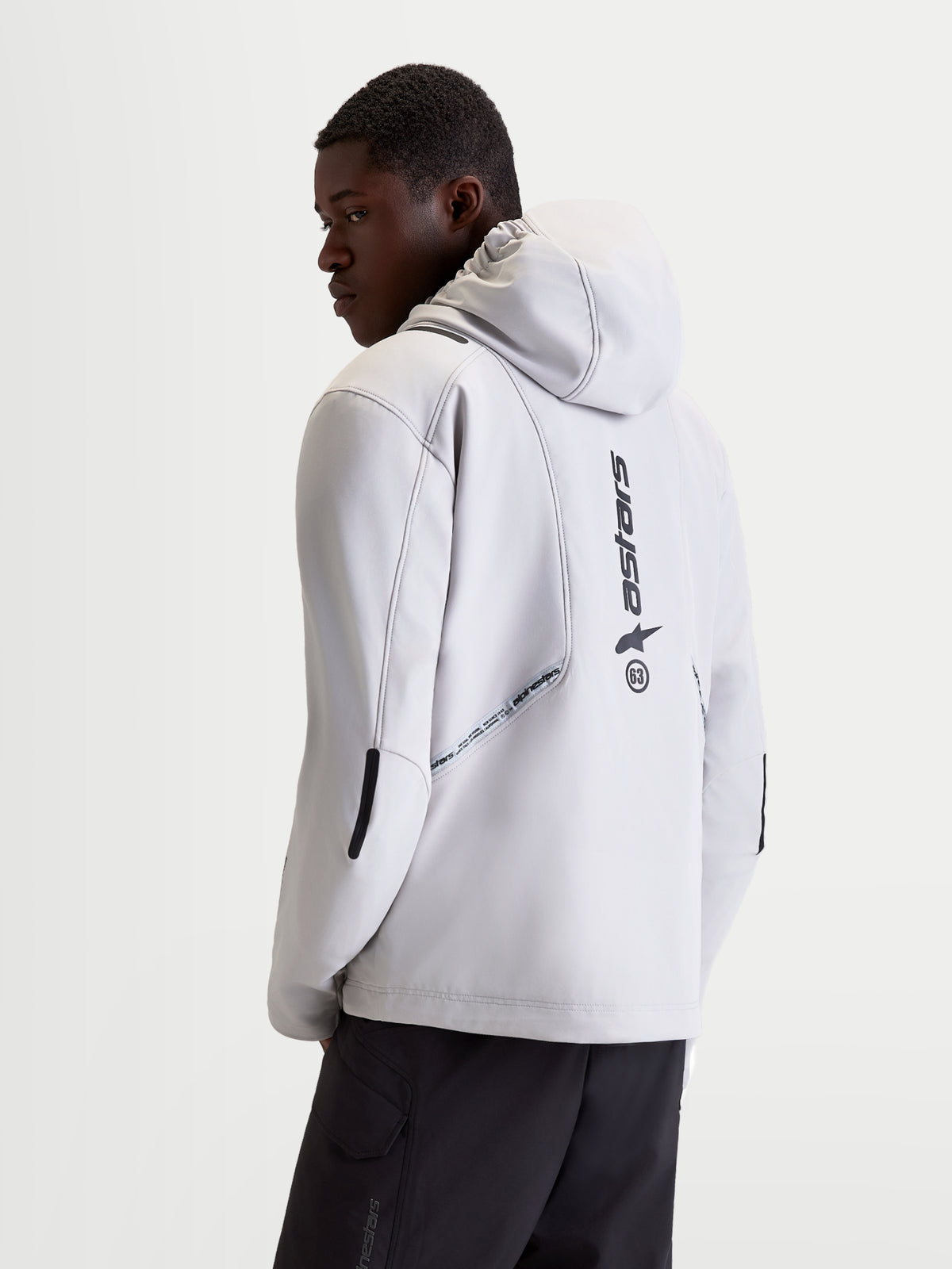 Alpinestars C-5 Drystar Jacket, men's urban contemporary motorcycle textile jacket in light gray and black, rear view on a model showing integrated hood, softshell construction, and vertical back logo details.