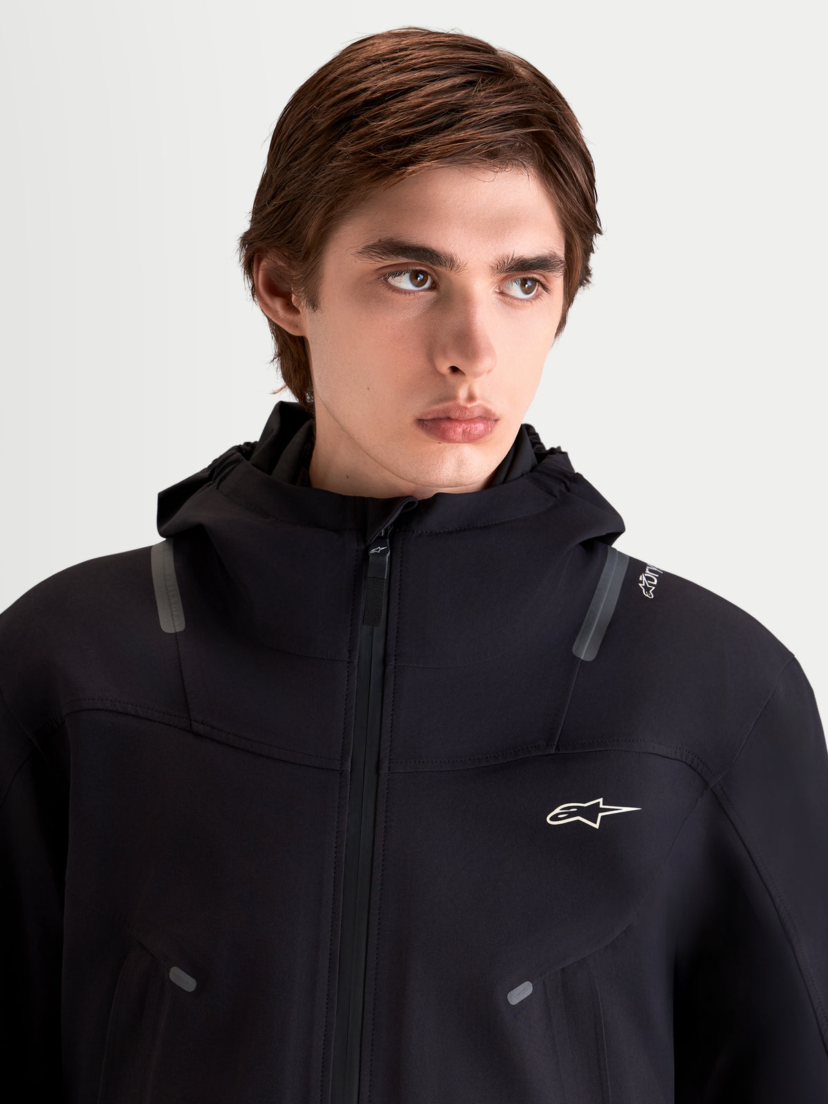 Alpinestars C 7 Drystar XF Jacke, urbane Motorradjacke für Herren in Schwarz, Nahaufnahme eines Models in der wasserdichten Textiljacke mit integrierter Kapuze und reflektierenden Details