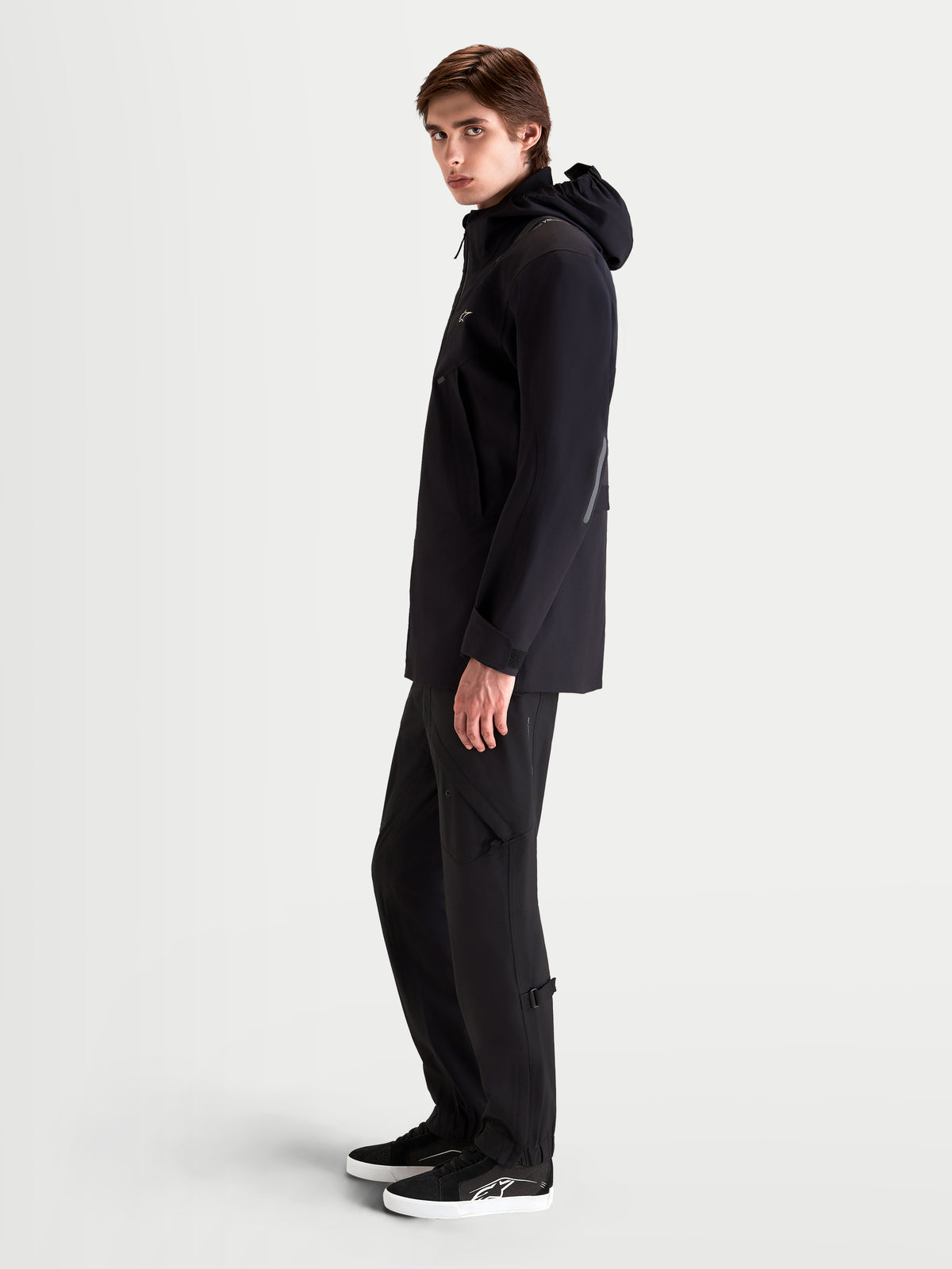 Alpinestars C 7 Drystar XF Jacke, urbane Motorradjacke für Herren in Schwarz, Seitenprofilansicht an einem Model mit integrierter Kapuze und passender Schutzkleidung