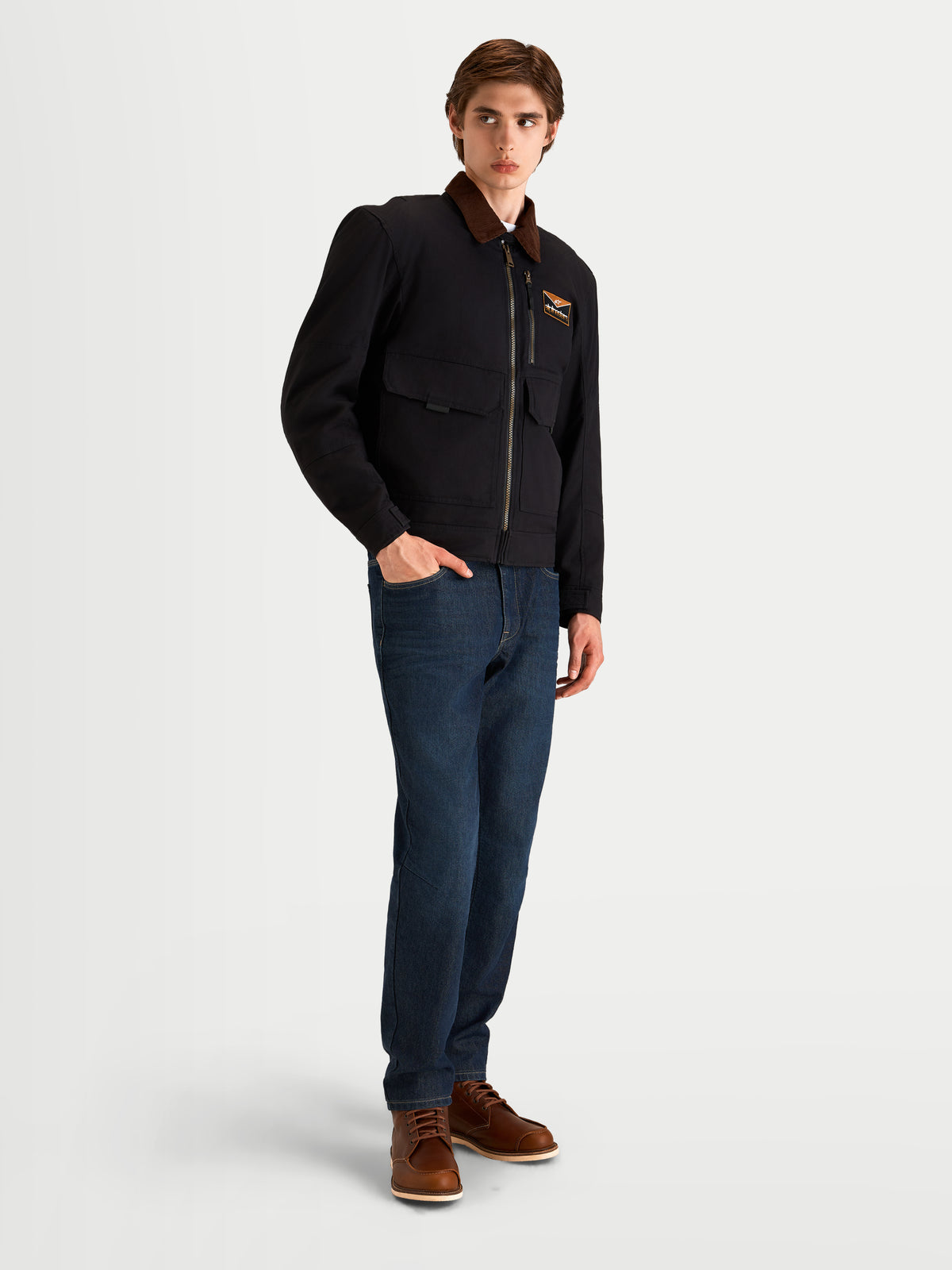 Alpinestars Mustang Waterproof Jacket, men's urban contemporary motorcycle jacket in dark anthracite and dark brown, three-quarter view on a model wearing workwear-styled textile riding gear with a corduroy collar.