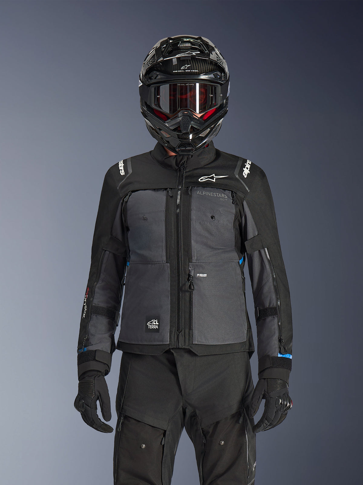 Alpinestars Cusco Drystar® Jacke, Schwarz und Dunkelgrau, Motorrad-Adventure-Touring-Jacke kombiniert mit passender schwarzer technischer Hose und einem Dual-Sport-Helm, zweifarbiges Design mit Ripstop-Einsätzen und Alpinestars-Branding