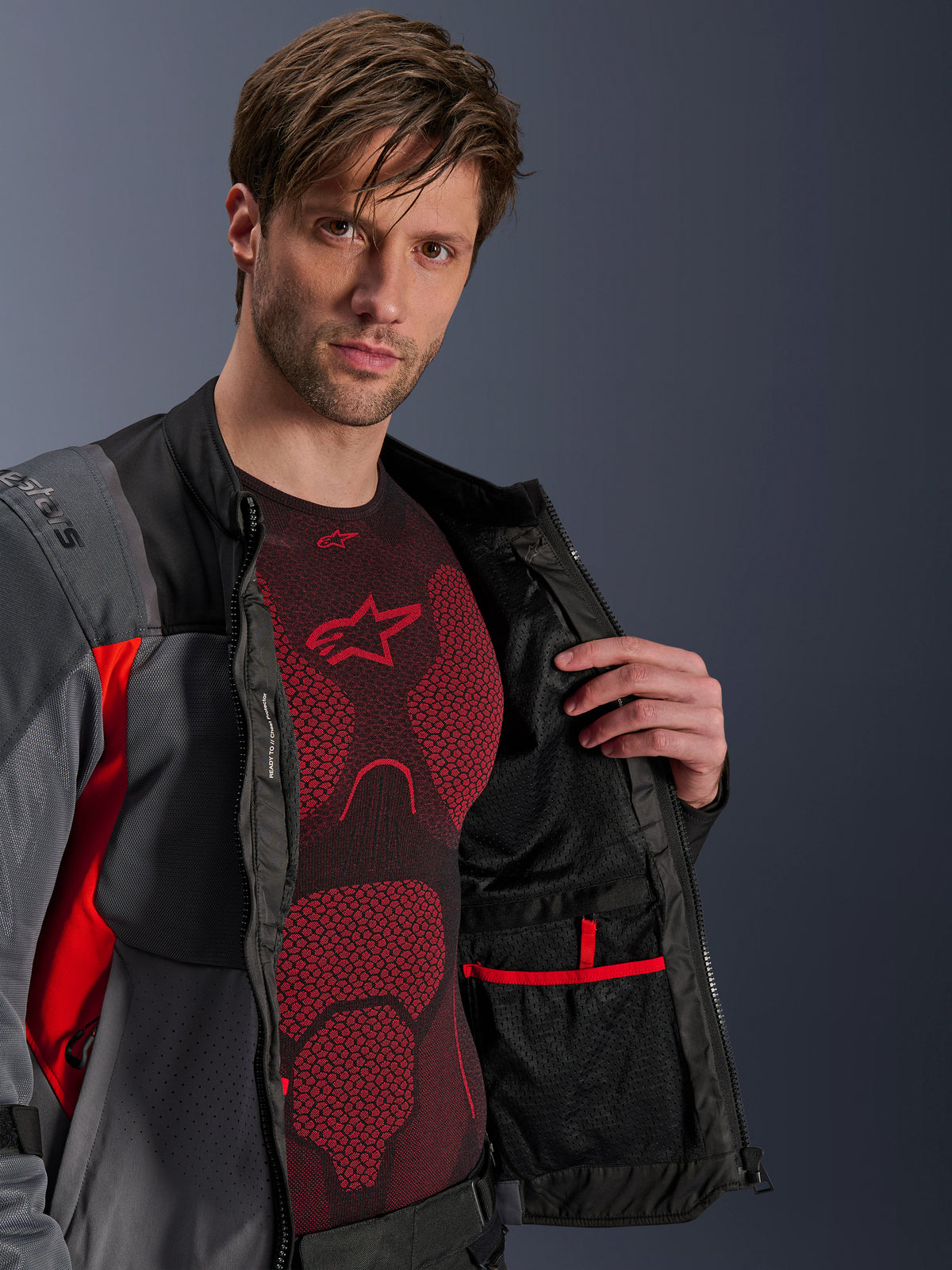 Alpinestars ST-2 Air Jacke, Herren-Adventure-Motorradjacke, Grau und Rot, geöffnet mit Mesh-Innenfutter und Tasche.