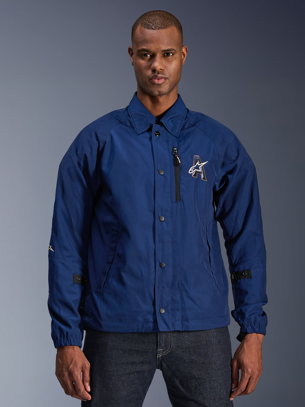 Alpinestars Revved WR Jacke, Herren-Urban-Motorradjacke, Marineblau, Coach-Stil mit Umlegekragen und Druckknöpfen vorne, schwarze Brusttasche mit Reißverschluss, großes 3D-Sticklogo, verstellbare Ärmellaschen, wasserabweisendes Material mit Satin-Finish