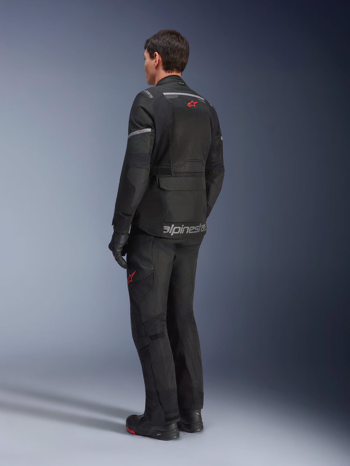 Alpinestars Andes Air Drystar® Hose und passende Jacke, Schwarz mit roten Stern-Logos, Adventure-Touring-Motorradausrüstung, Rückansicht, mit Mesh-Belüftungseinsätzen und reflektierenden Details.