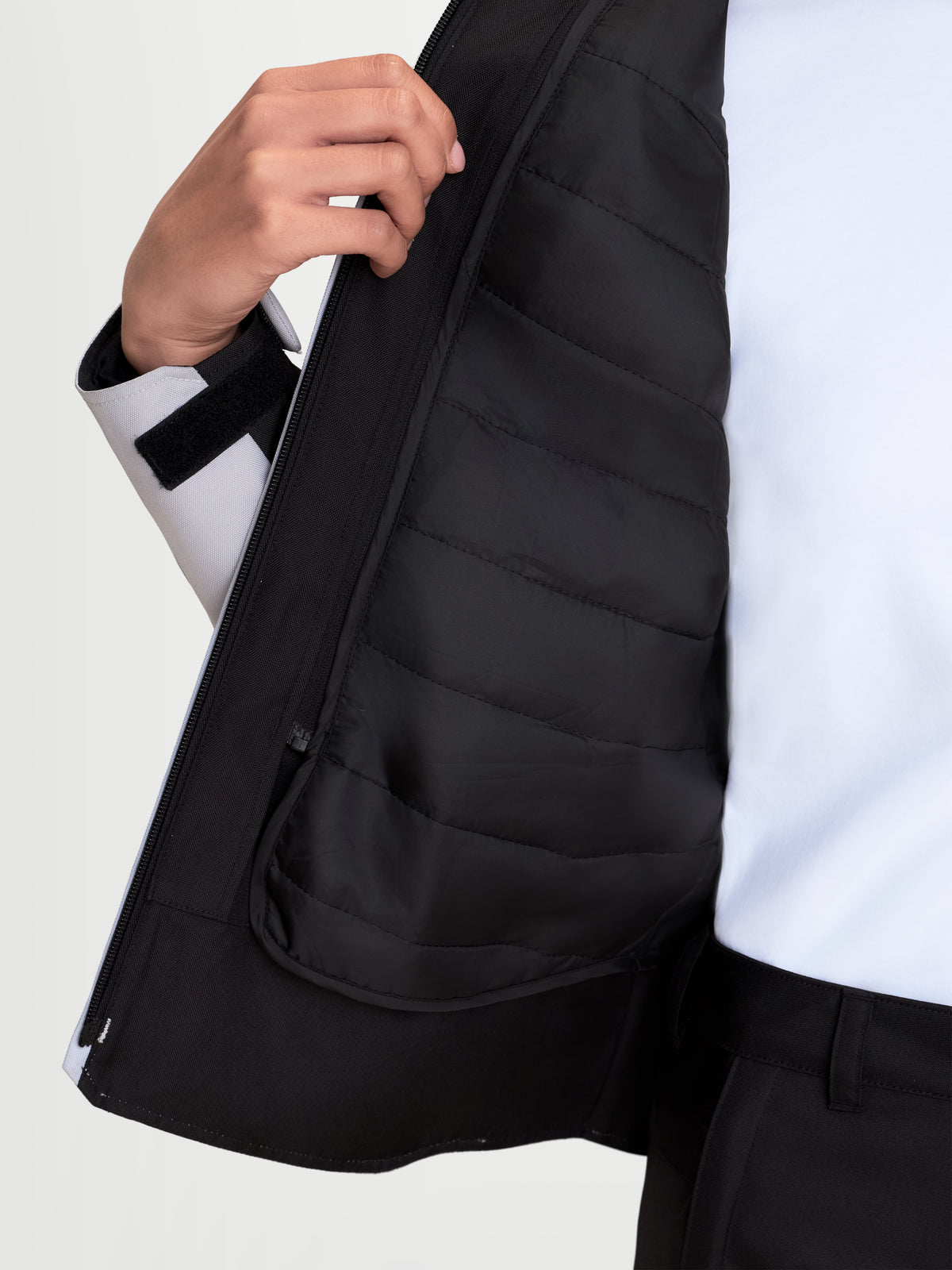 Alpinestars Stella C 1 Waterproof Jacke, Damen-Motorradjacke in Eisgrau und Schwarz, Nahaufnahme der innenseitigen thermoisolierten Weste und des Frontreißverschlusses, getragen von einem Model