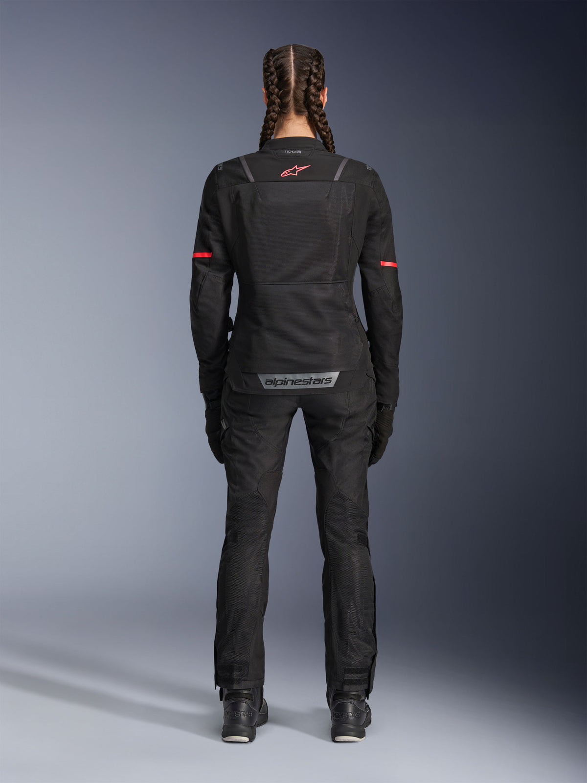Alpinestars Stella Andes Air Drystar® Hose, Damen-Motorradhose, Schwarz, Rückansicht kombiniert mit einer passenden Mesh-Jacke mit roten Akzenten, betont Mesh-Belüftungseinsätze und reflektierendes Branding am unteren Rücken, konzipiert für Adventure- und Straßentouren.