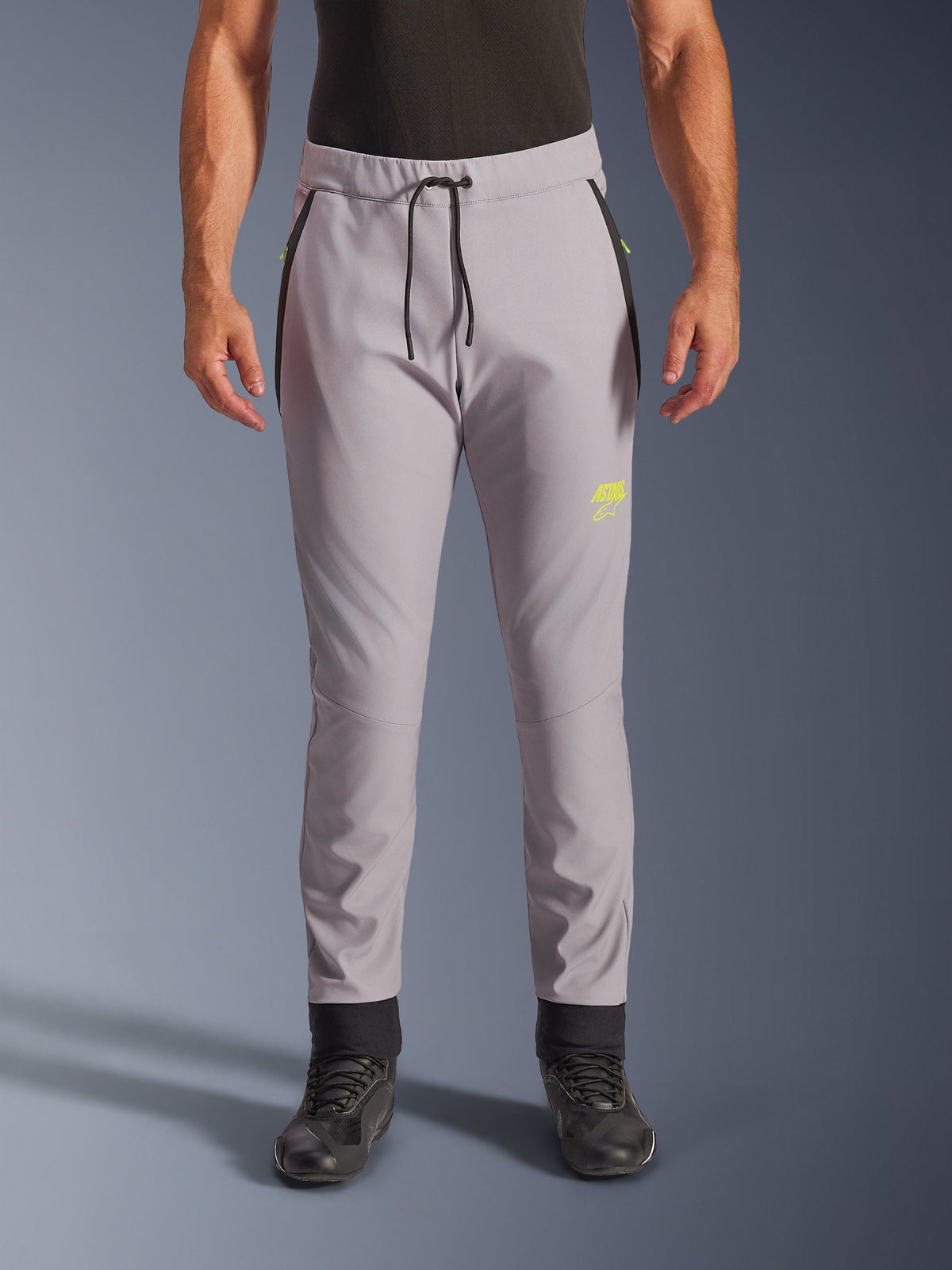 Alpinestars Aeroshell Pants, Mid Gray and Yellow Fluo, crossover softshell motorcycle pants, featuring a black drawstring waist and fitted ankle cuffs, yellow logo on left thigh, pre-curved knees, sporty jogger-style silhouette