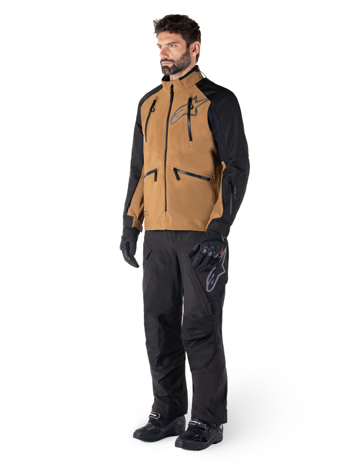 Alpinestars Hyde XT Drystar® Pants, Adventure Motorcycle Pants, Black, worn with a brown and black technical jacket, black gloves and boots, featuring an over-the-boot design for off-road and dual-sport riding