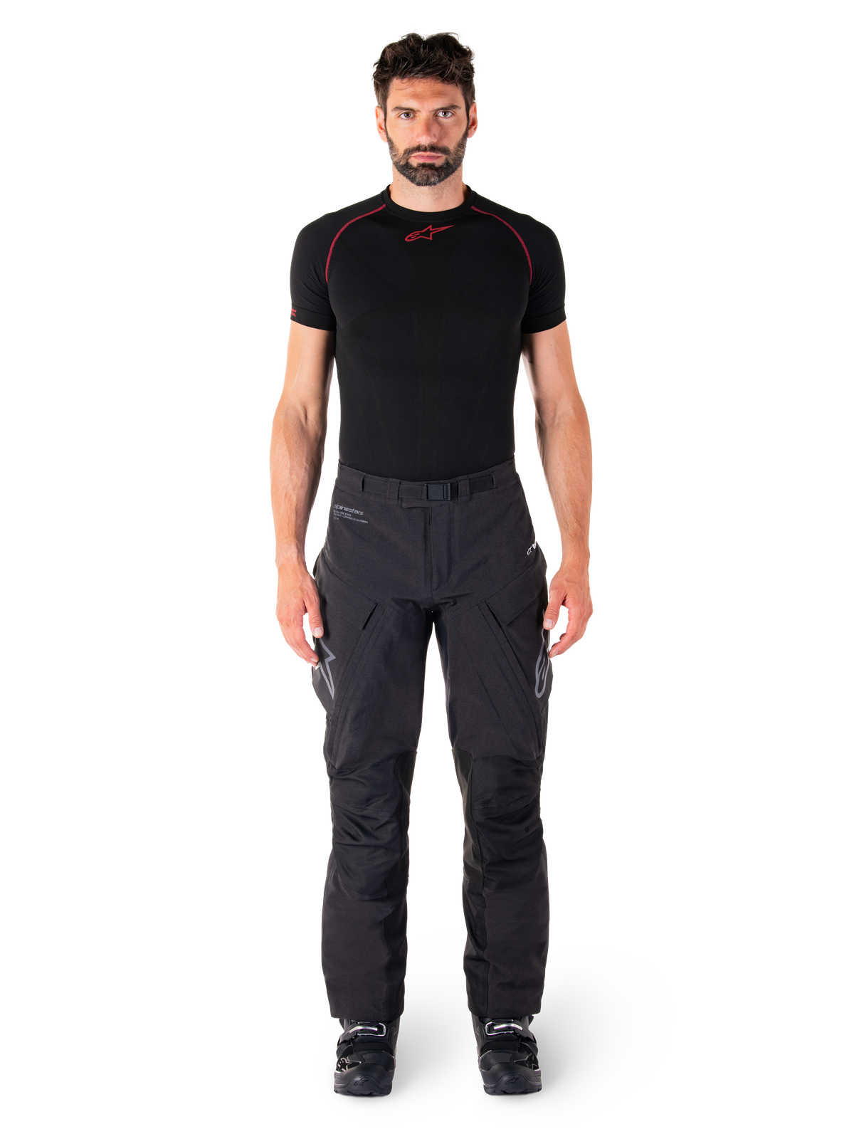 Alpinestars Hyde XT Drystar® Pants, Adventure Touring Motorcycle Pants, Black, worn by a model with a black short-sleeve base layer and black boots, featuring technical stretch material, reinforced knee panels, and ergonomic cargo pockets.
