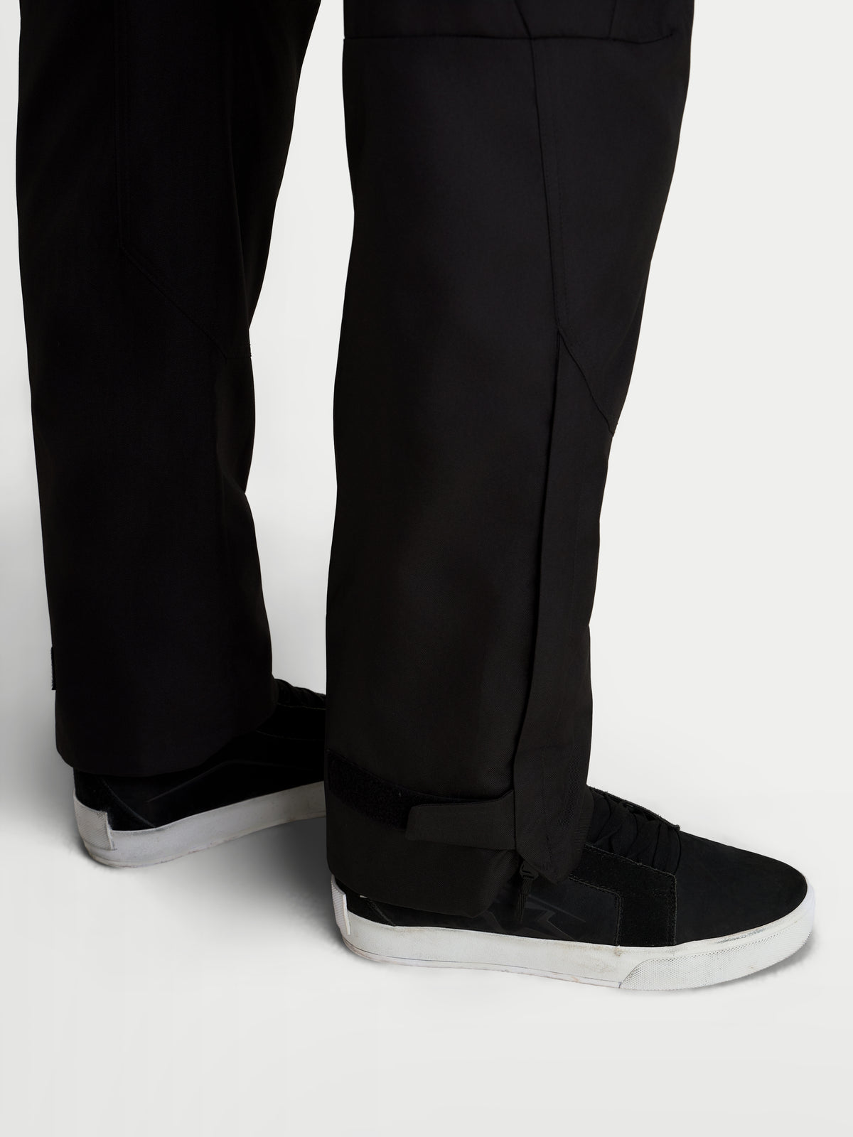 Alpinestars C-1 Waterproof Pants, men's urban contemporary motorcycle riding pants in black, close-up view showing straight fit lower leg construction and extended leg openings worn with riding shoes