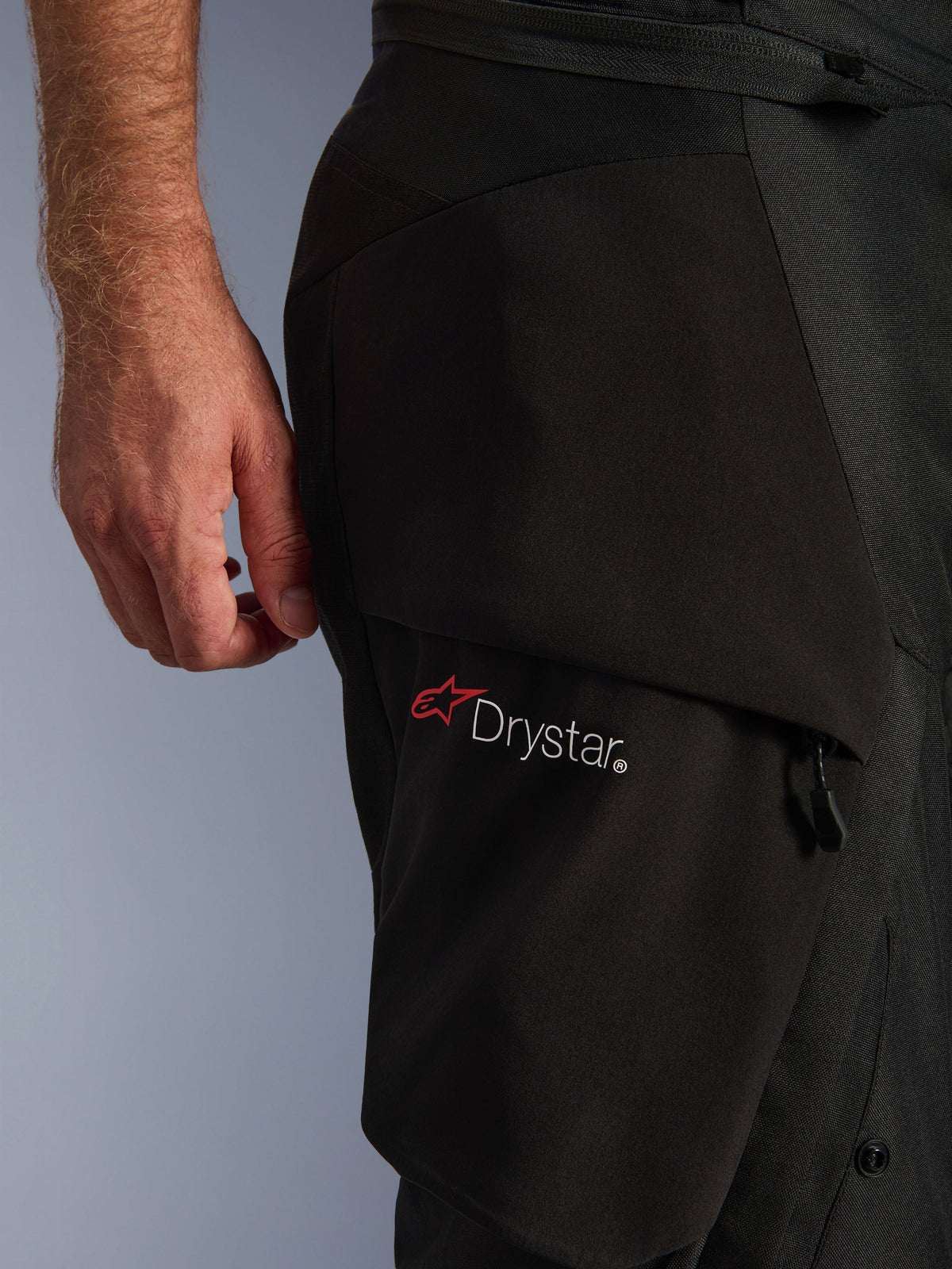 Alpinestars Andes V4 Drystar® Hose, Schwarz, Nahaufnahme des Oberschenkelbereichs mit dem Drystar®-Logo auf einer Cargotasche, technisches Textilmaterial mit verstärkten Einsätzen, wasserdichte Adventure-Motorradhose