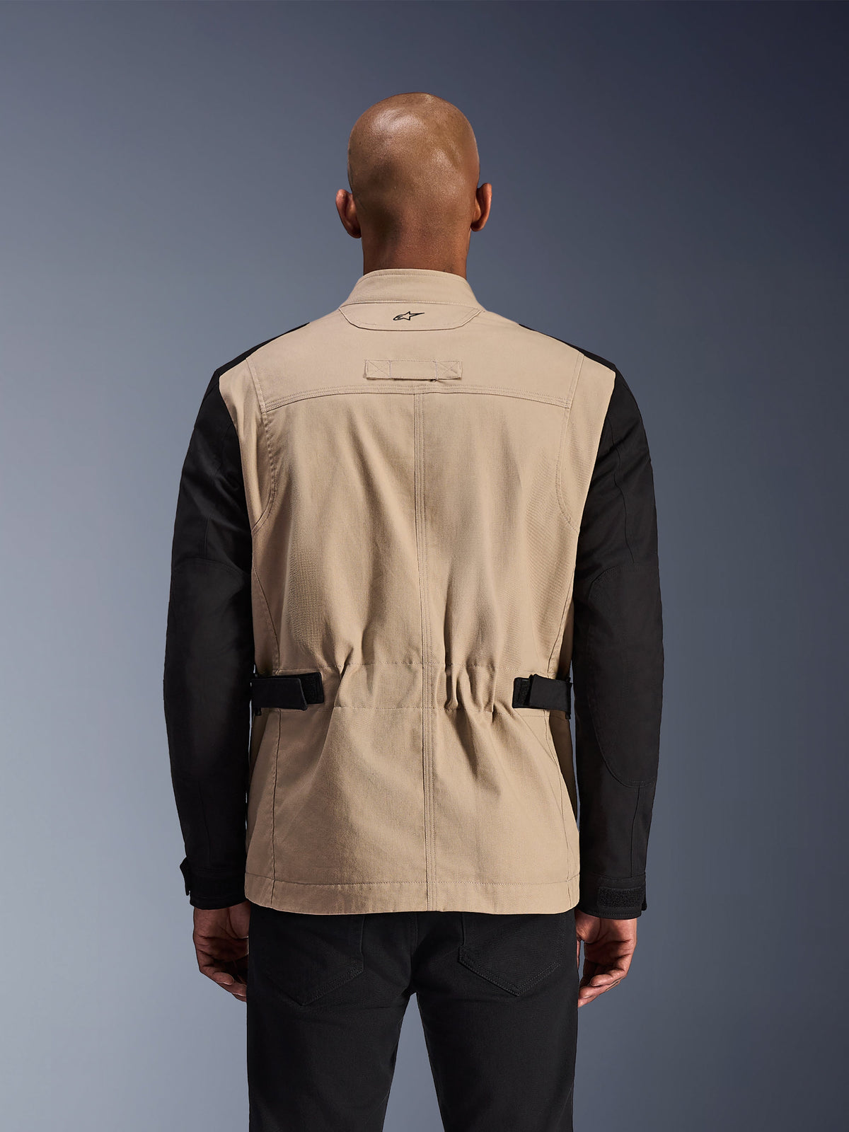 Alpinestars Dice Jacket, Urban Motorcycle Jacket, Aluminum and Black, back view on a model, featuring pleated shoulders for mobility, adjustable waist straps, and a rugged polycotton twill construction.