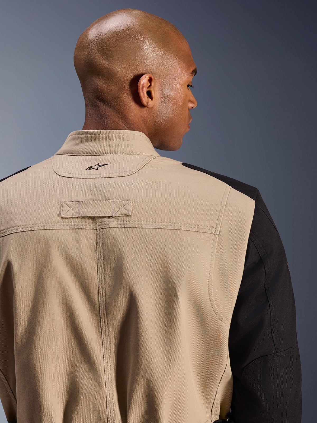 Alpinestars Dice Jacket, Urban Motorcycle Jacket, Tan and Black, close-up detail of the back collar and shoulder, featuring an embroidered logo, rugged polycotton twill construction, street-ready workwear style