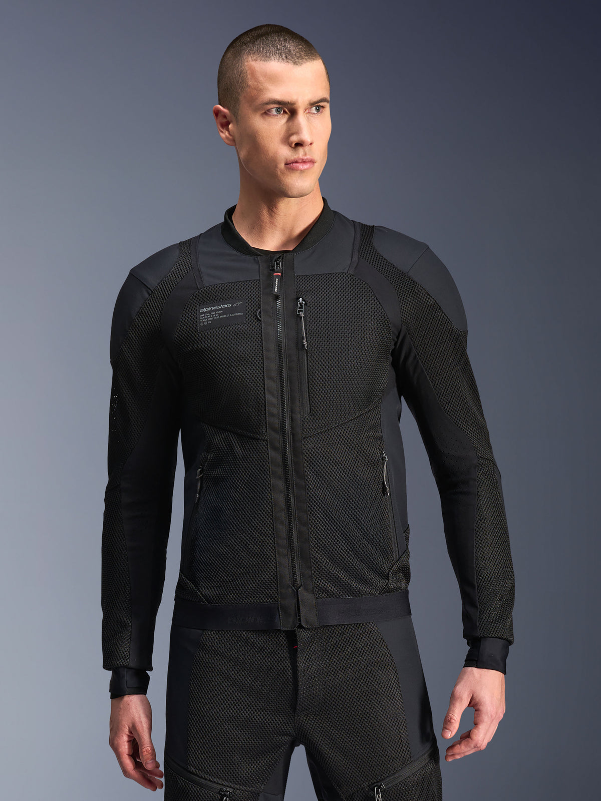 Alpinestars Troop-Air Pro Jacket, Black Motorcycle Mesh Jacket, Male model wearing armored air jacket with 2D tech mesh structure, front zipper, zippered pockets, technical performance riding gear