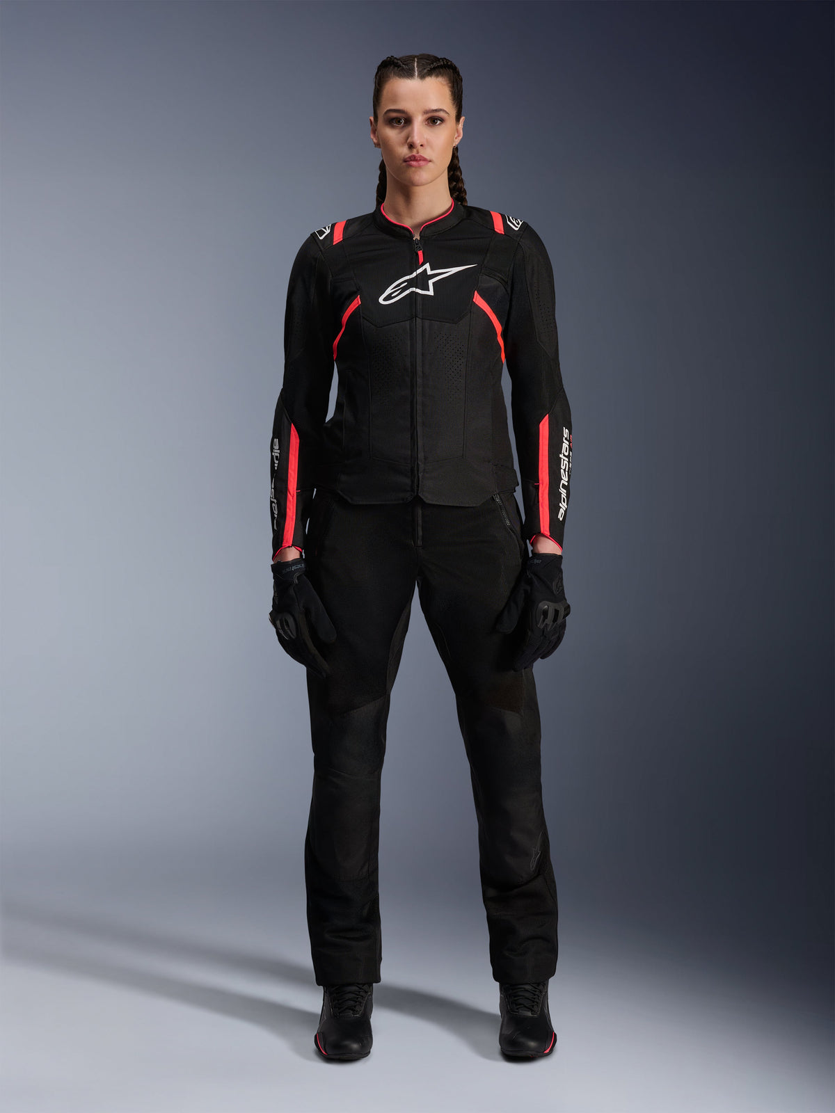 Alpinestars Stella T-SPS Air v2 Jacke, Damen-Motorradjacke, Schwarz und Diva Pink, Vorderansicht, weißes Brustlogo, Mesh-Belüftungseinsätze, getragen mit schwarzer Hose und Handschuhen, elegante urbane Fahrausrüstung