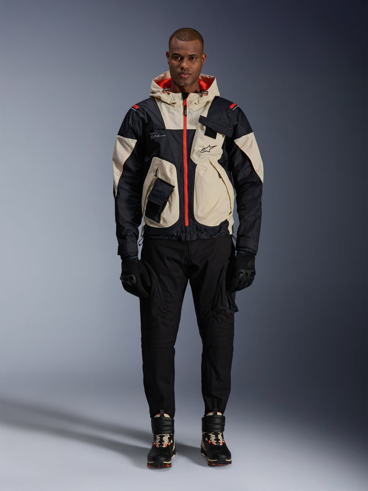 Alpinestars Mogress Air Jacke, urbane Herren-Motorradjacke, Schwarz und Almond mit Hot Orange, getragen von einem Model.