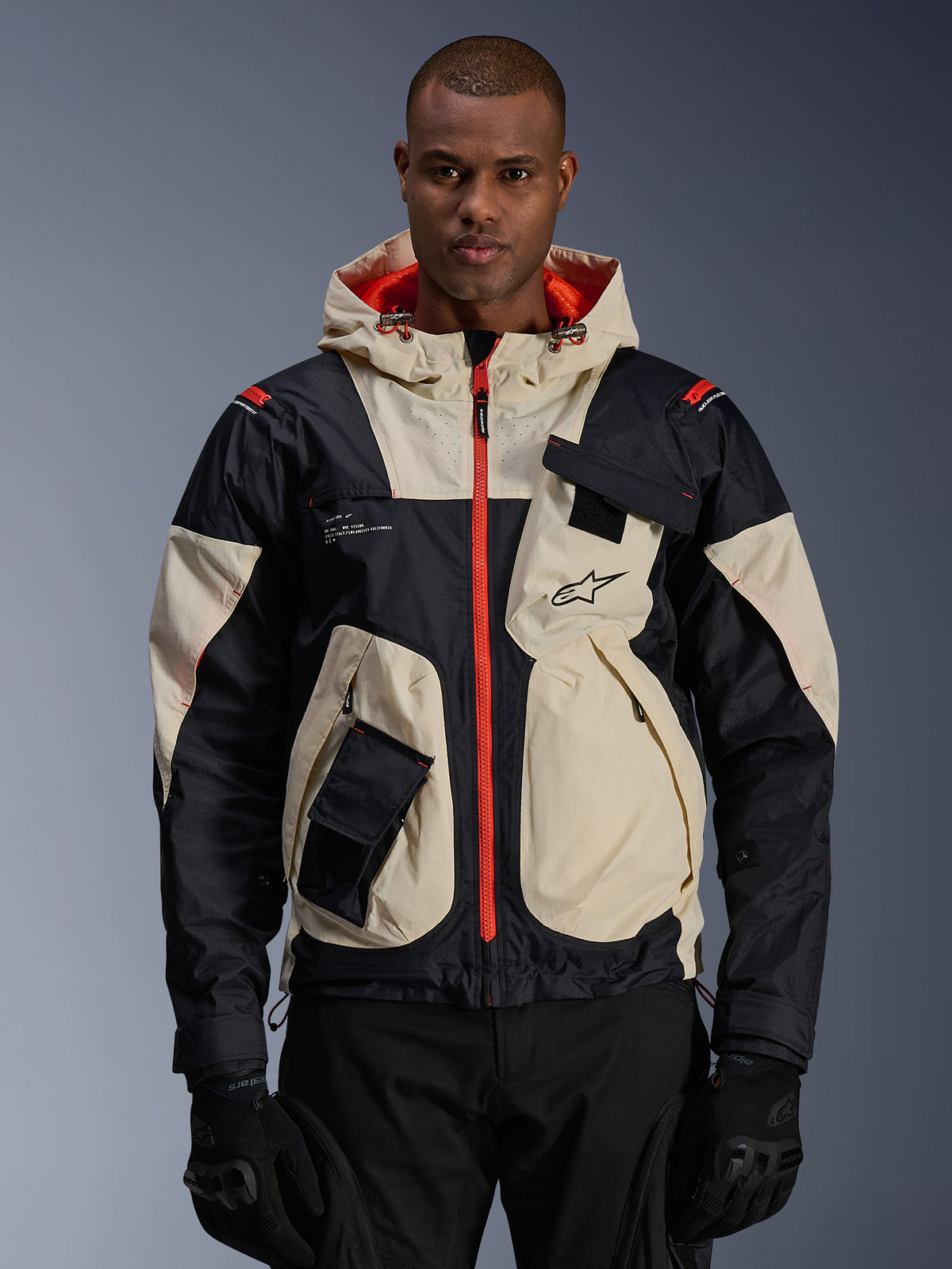 Alpinestars Mogress Air Jacke, urbane Herren-Motorradjacke in Schwarz und Almond mit Hot Orange und Utility-Taschen.