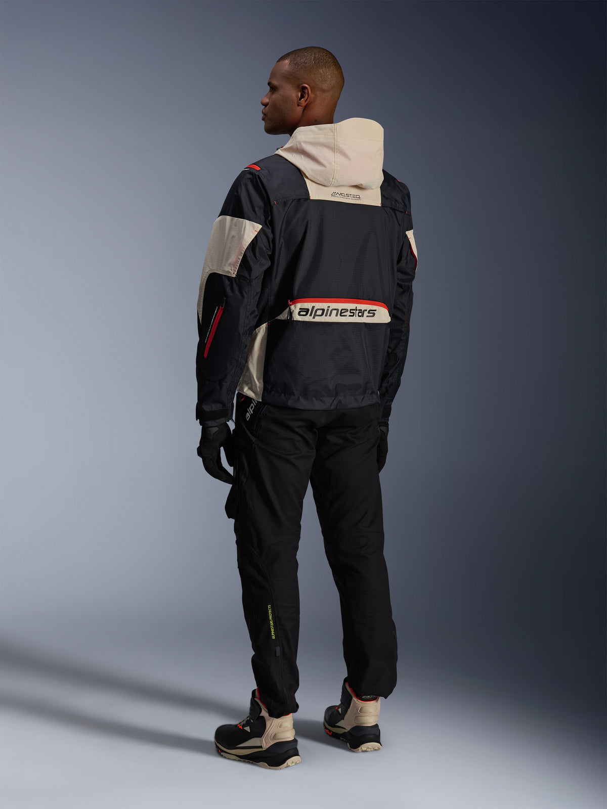 Alpinestars Mogress Air Jacke, urbane Motorradjacke in Schwarz und Mandel mit Hot Orange, Rückansicht mit großem Branding.