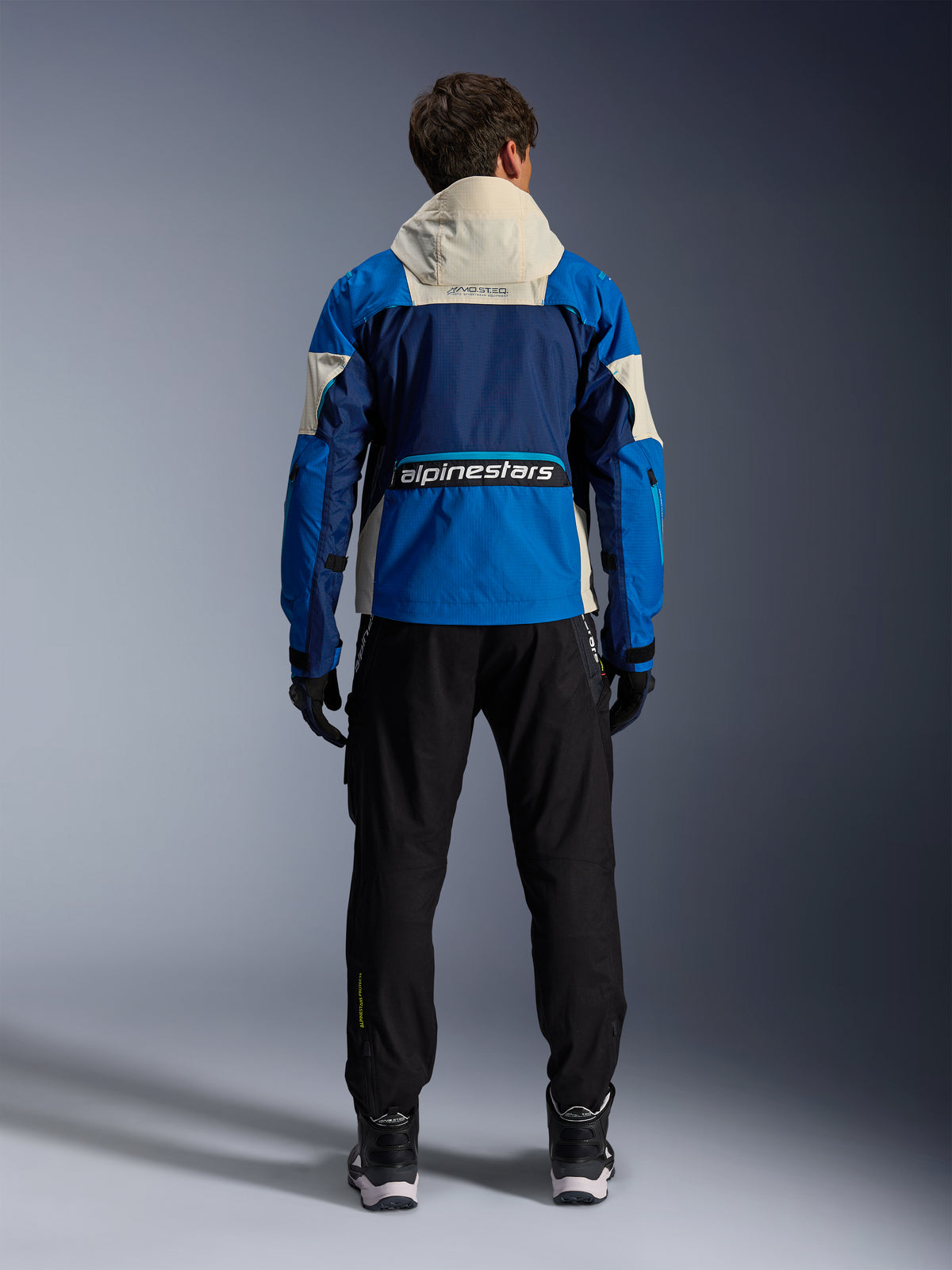 Alpinestars Mogress Air Jacke, Herren-Motorradjacke für Urban Riding, Blau und Almond, CE-zertifiziertes Ripstop-Gewebe, Rückansicht mit Kapuze und Alpinestars-Logo.