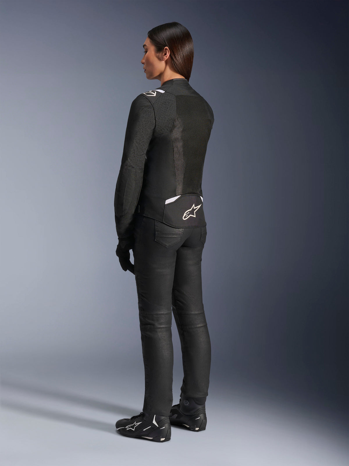 Alpinestars Stella T-Sps Air V2 Jacket, Black and White, back view showing mesh panels and logo on the lower back, paired with black riding pants and motorcycle shoes, sporty textile road gear for women