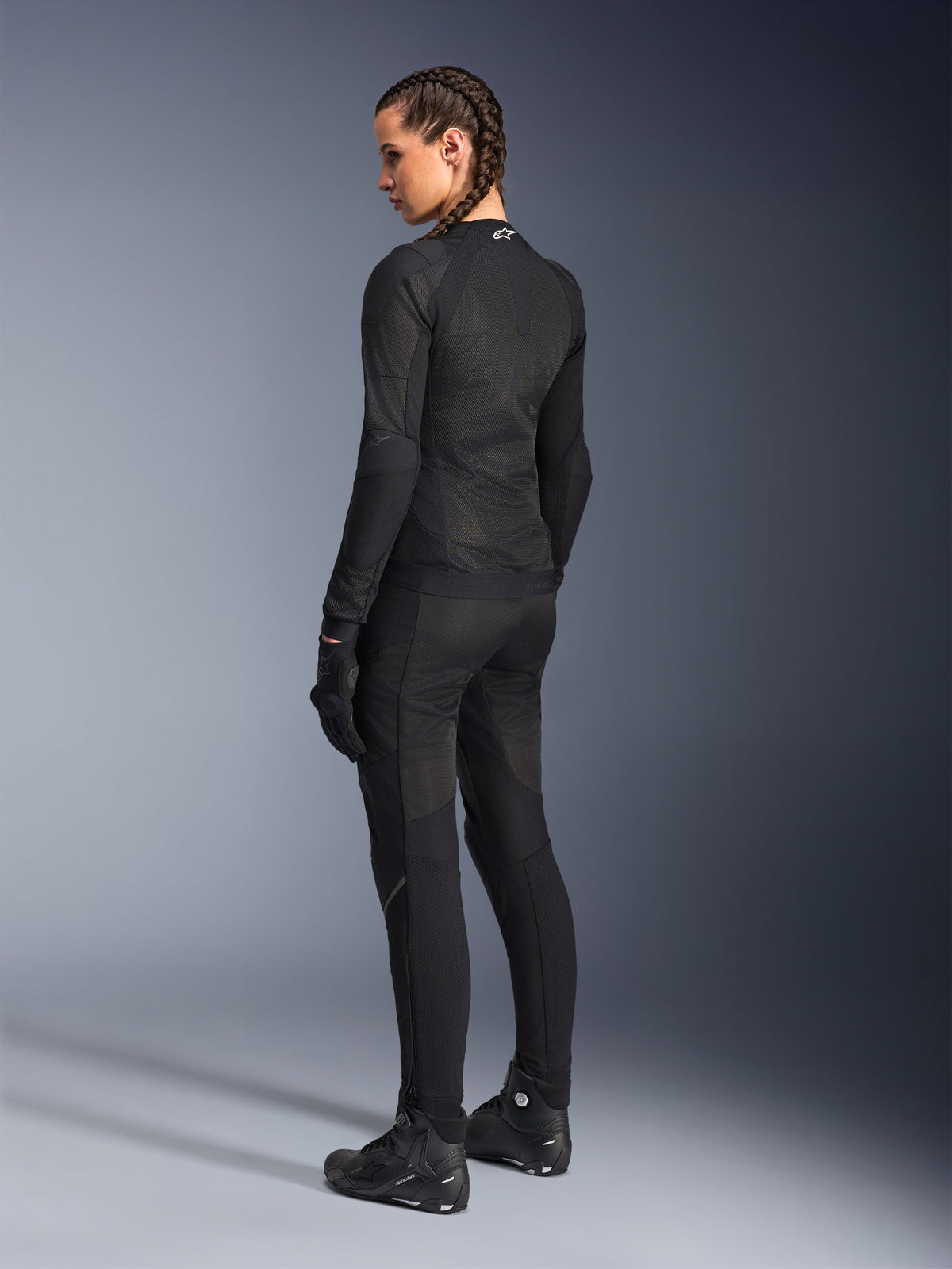 Alpinestars Stella Troop-Air Damenjacke, Schwarz, Rückansicht, getragen mit passender schwarzer Motorradhose, Handschuhen und Stiefeln, Slim-Fit-Konstruktion aus technischem Mesh für den urbanen Fahrstil