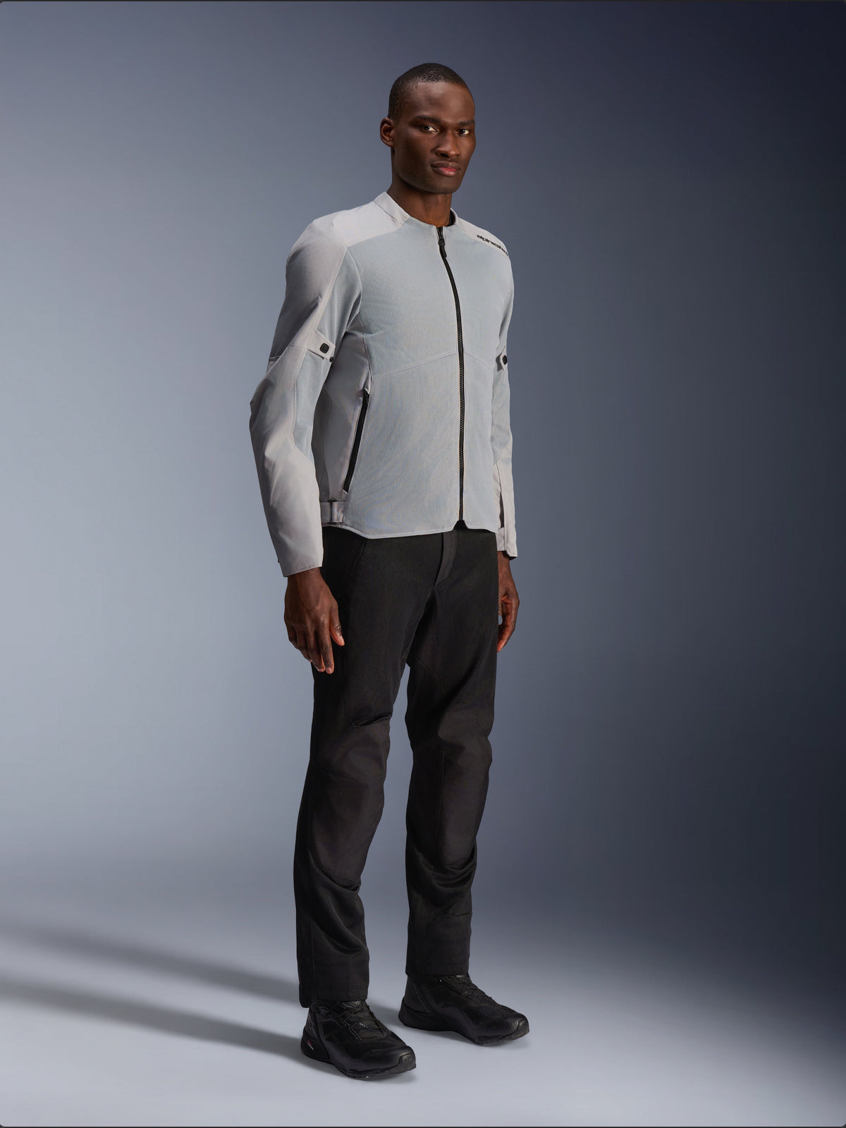 Alpinestars C-1 Air Jacke in Silber und Grau, Urban-Motorradjacke, leichte Textil- und Mesh-Konstruktion, getragen mit schwarzer Motorradhose und schwarzem Schuhwerk, klares, modernes Design für Stadtfahrten