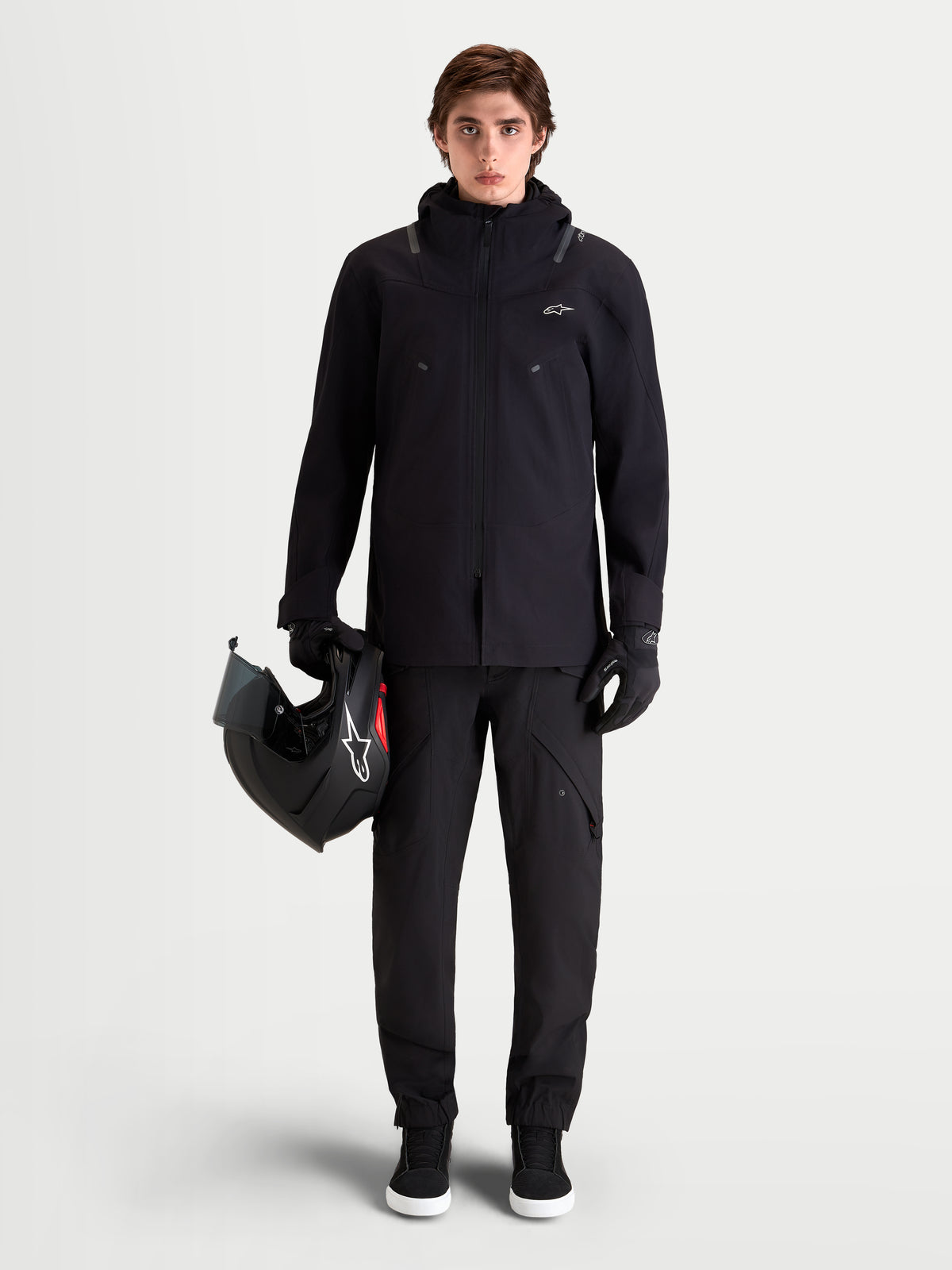 Alpinestars Juggernaut V2 Drystar Hose, urbane Herren-Motorradhose in Schwarz, Frontansicht an einem Model mit passender Jacke und Helm, wasserdichte Textilkonstruktion