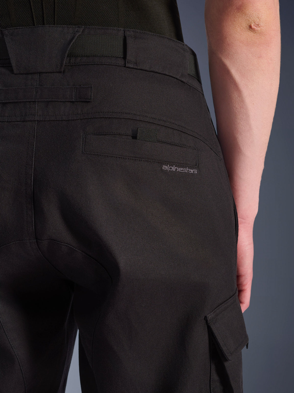 Nahaufnahme der Alpinestars Flex-AST Cargo-Hose in Schwarz, urbane Motorradhose mit einer detailreichen Gesäßtasche mit dezentem Branding, großen Gürtelschlaufen und einer seitlichen Cargotasche aus strapazierfähigem Stretch-Textil.