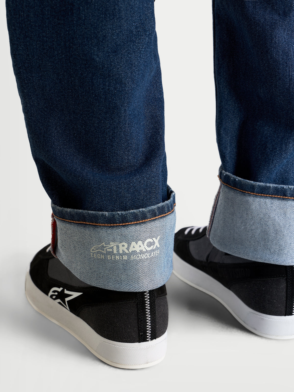 Alpinestars Flex Ast 8 Denim Hose, Motorrad-Jeans in Mittelblau, Nahaufnahme des umgeschlagenen Saums mit interner A-TRAACX Single-Layer-Denim-Prägung und Webkanten-Finish