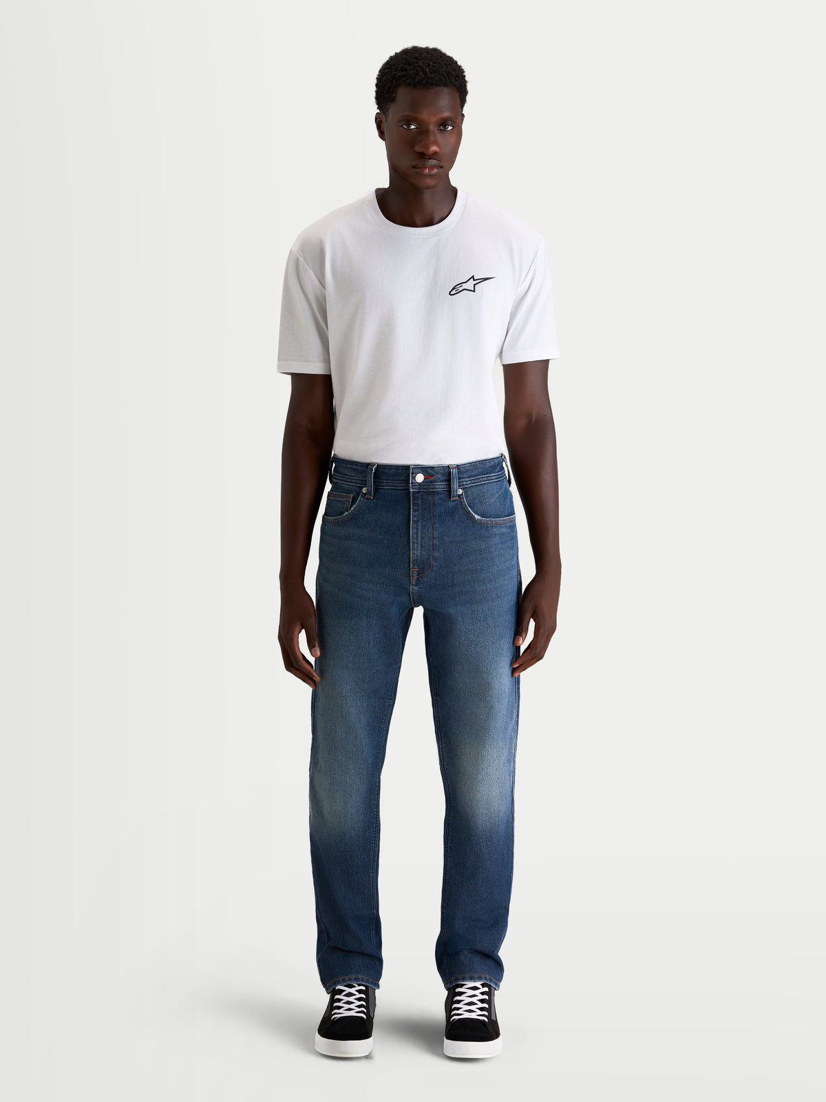 Alpinestars Flex Ast 8 Denim Hose, Herren-Urban-Motorradjeans in Mittelblau, Straight-Fit-Design, getragen von einem Model mit weißem T-Shirt, AA-zertifizierter Schutz
