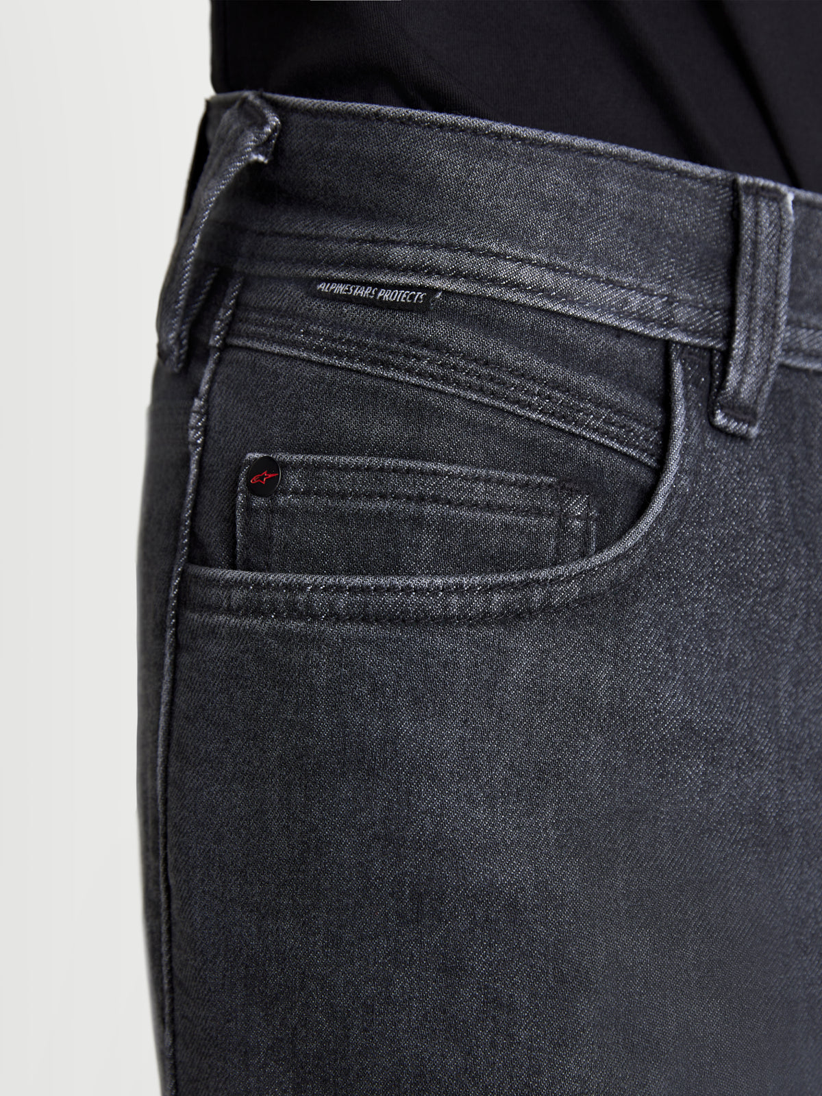 Alpinestars Flex Ast 7 Denim Hose, Herren-Motorradjeans in verwaschenem Schwarz, Nahaufnahme der Taschenkonstruktion mit gebrandeten Nieten und Alpinestars Protects gewebtem Etikett