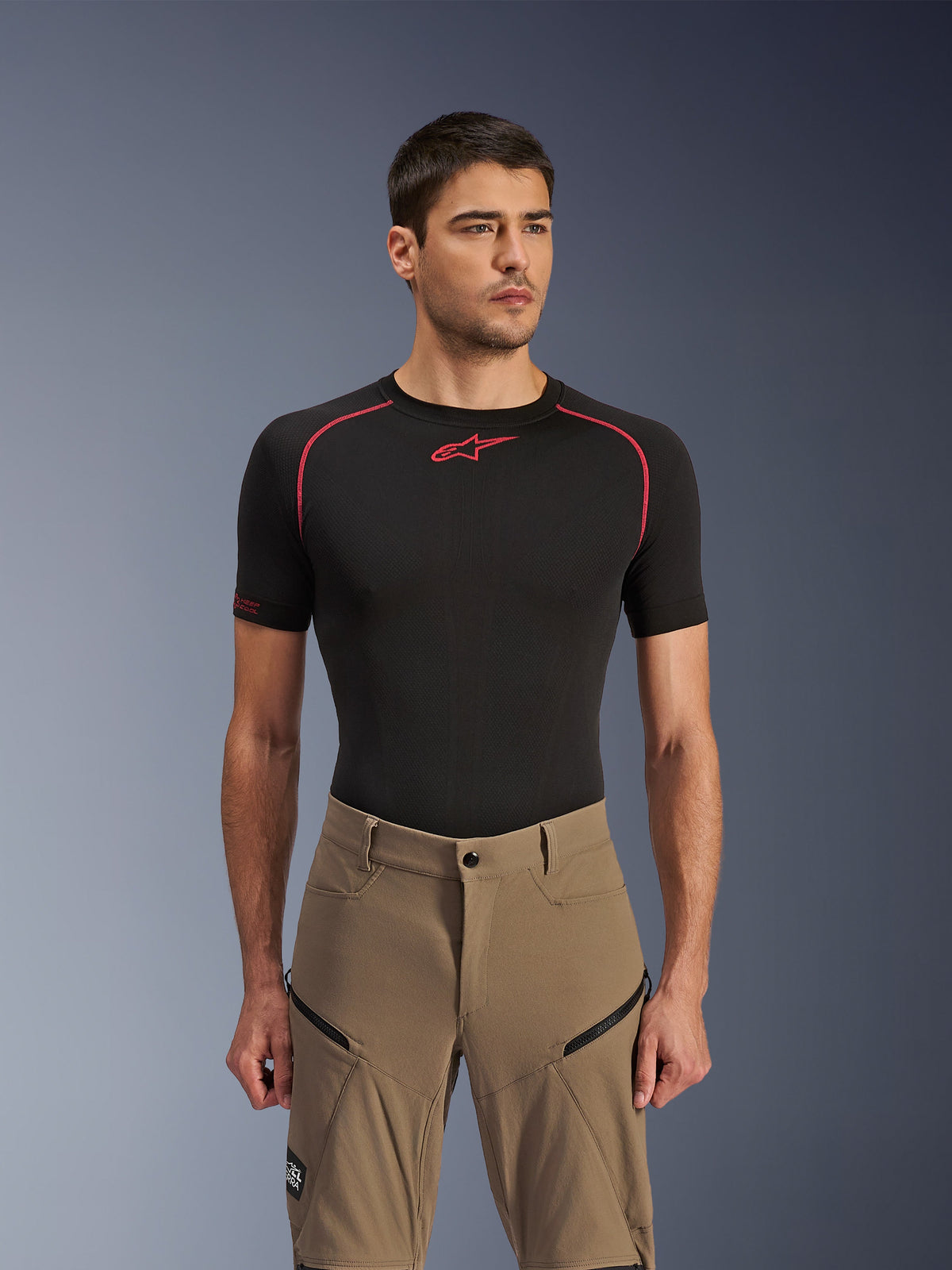 Alpinestars Flex-AST Explorer Pants, Adventure Motorcycle Pants, Walnut Black, worn by a model with a black base layer shirt, featuring diagonal zippered cargo pockets and durable stretch textile construction.