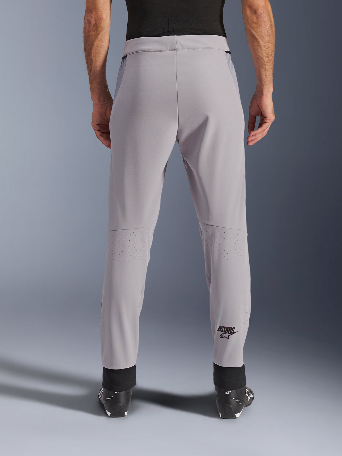 Alpinestars Aeroshell Airflow Hose, Motorradhose, Mid Gray, Rückansicht mit laserperforierten Zonen an den Waden und schwarzem Astars-Logo, Textil-Softshell-Konstruktion mit schwarzen Knöchelbündchen und Mesh-Hüfteinsätzen.
