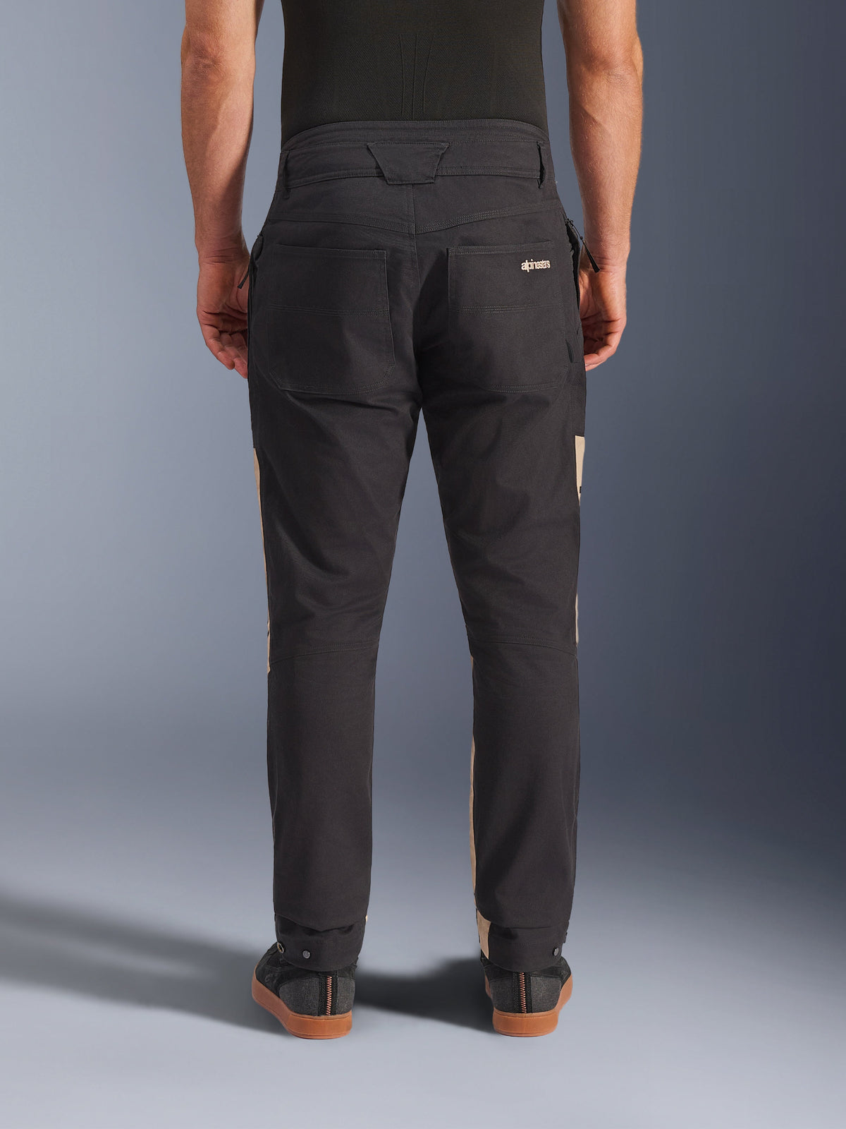 Alpinestars Flex-AST Canvas Pants in Black Aluminum, back view showing utilitarian design with rear pockets and tan side accents, stretch polycotton material, urban motorcycle gear for men.