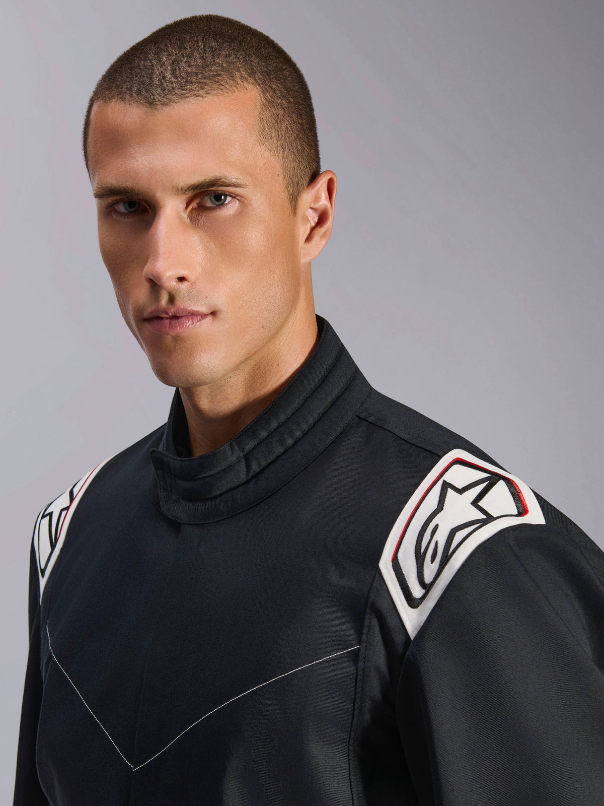 Alpinestars Kart Indoor V2 Suit, Black, close-up view of the shoulders and collar, white shoulder epaulets with black Astars logo, ergonomic collar design, durable poly-cotton twill construction for indoor karting
