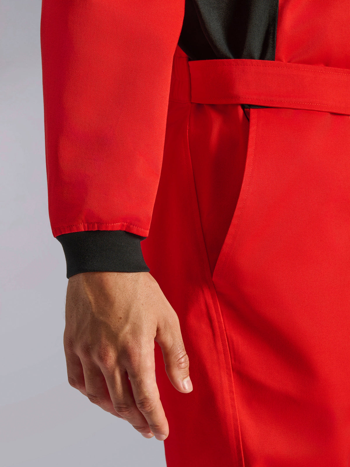 Alpinestars Kart Indoor V2 Suit, Red karting suit, close-up showing black knitted wrist cuff, adjustable waist belt, and durable single-layer twill material