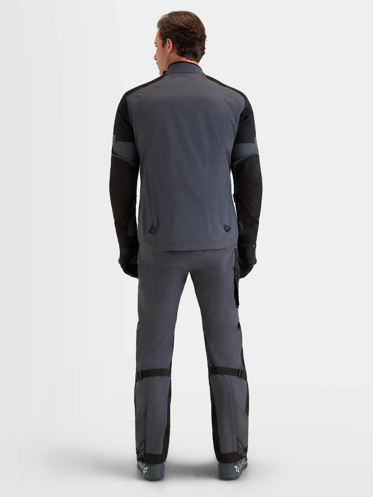 Alpinestars Arenis Gore-Tex® Gear Set, Herren-Adventure-Motorradjacke und -hose in Grau und Schwarz, Rückansicht auf einem Model in wasserdichter All-Terrain-Schutzausrüstung