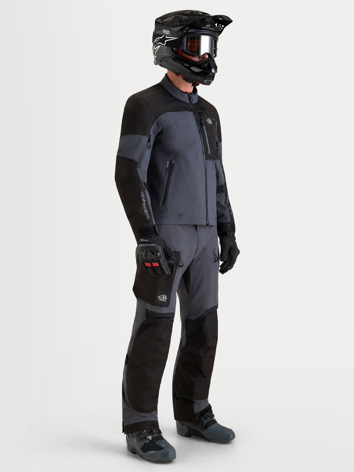 Alpinestars Arenis Gore-Tex Jacke, Herren-Adventure-Motorradjacke in Schwarz und Dunkelgrau, Seitenprofil-Ansicht an einem Model mit Schutzbekleidung