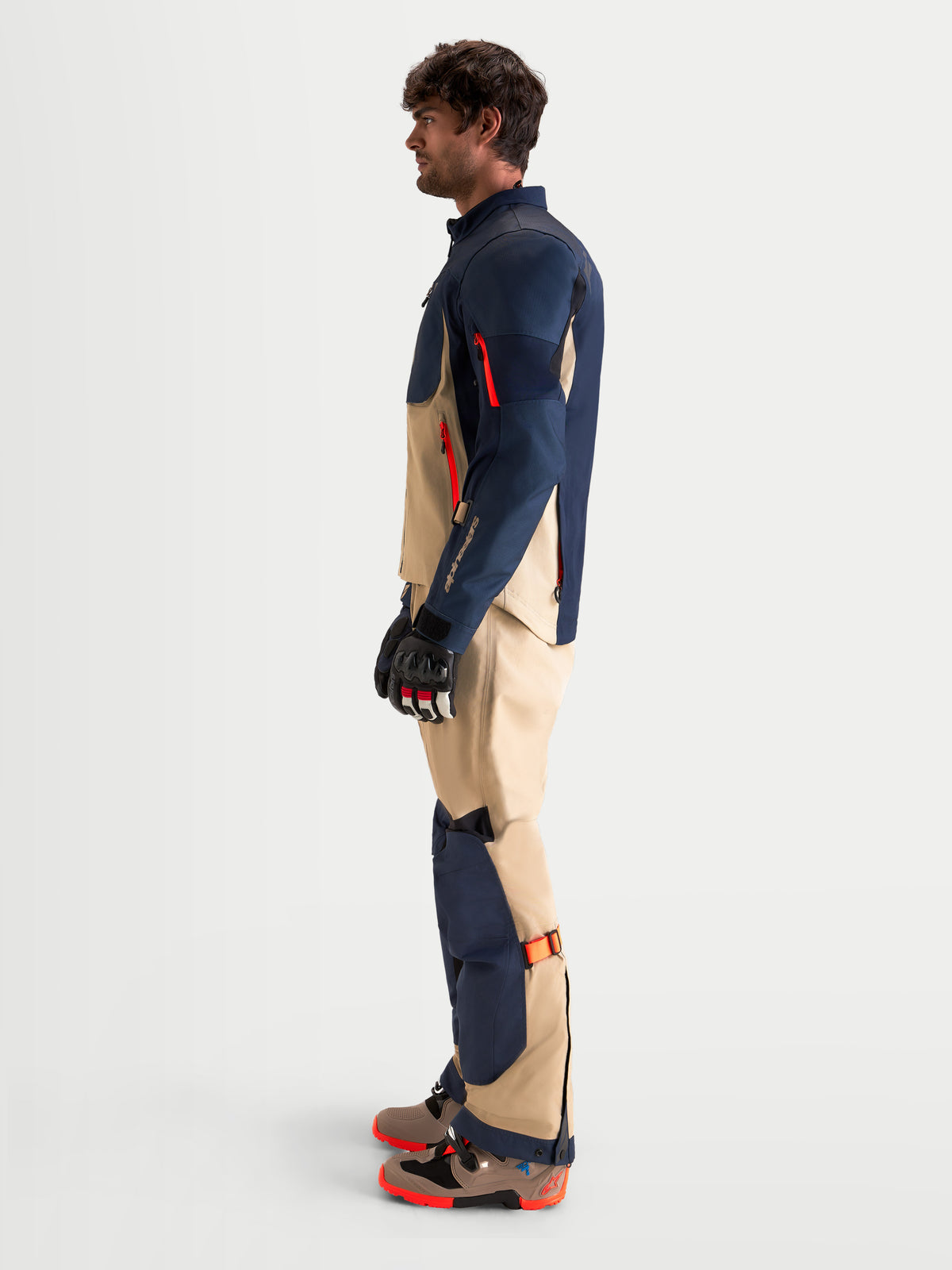 Alpinestars Arenis Gore-Tex Gear Set, Herren-Adventure-Motorradjacke und -hose in Nachtblau und Aluminium, Seitenprofilansicht getragen von einem Model mit passenden Handschuhen und Stiefeln, AA-zertifizierte, wasserdichte All-Terrain-Schutzausrüstung